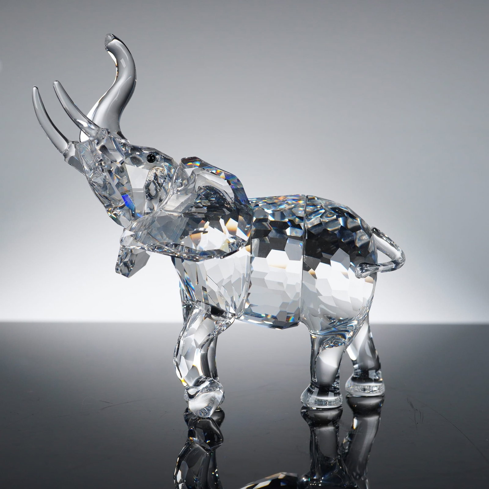 Swarovski Mother Elephant 678945 Crystal Figurine: This Swarovski crystal figurine, identified as the "Mother Elephant" (model number 678945), is a premier example of the company's precision-cut lead crystal artistry. The piece features a multi-facete