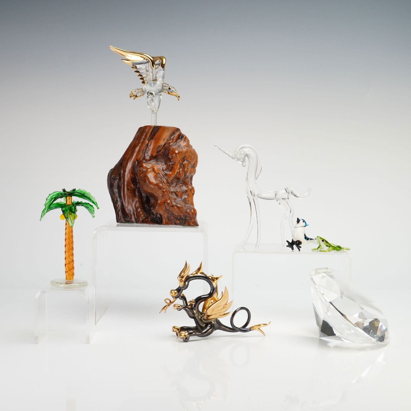 Glass Baron and Artisan, 7pc Glass Menagerie Figurines and Large Chaton: This seven-piece collection features an assortment of hand-blown and faceted glass figurines. The set includes a clear glass eagle with 22 karat gold accents, attributed to Glass Baron, mounted via a
