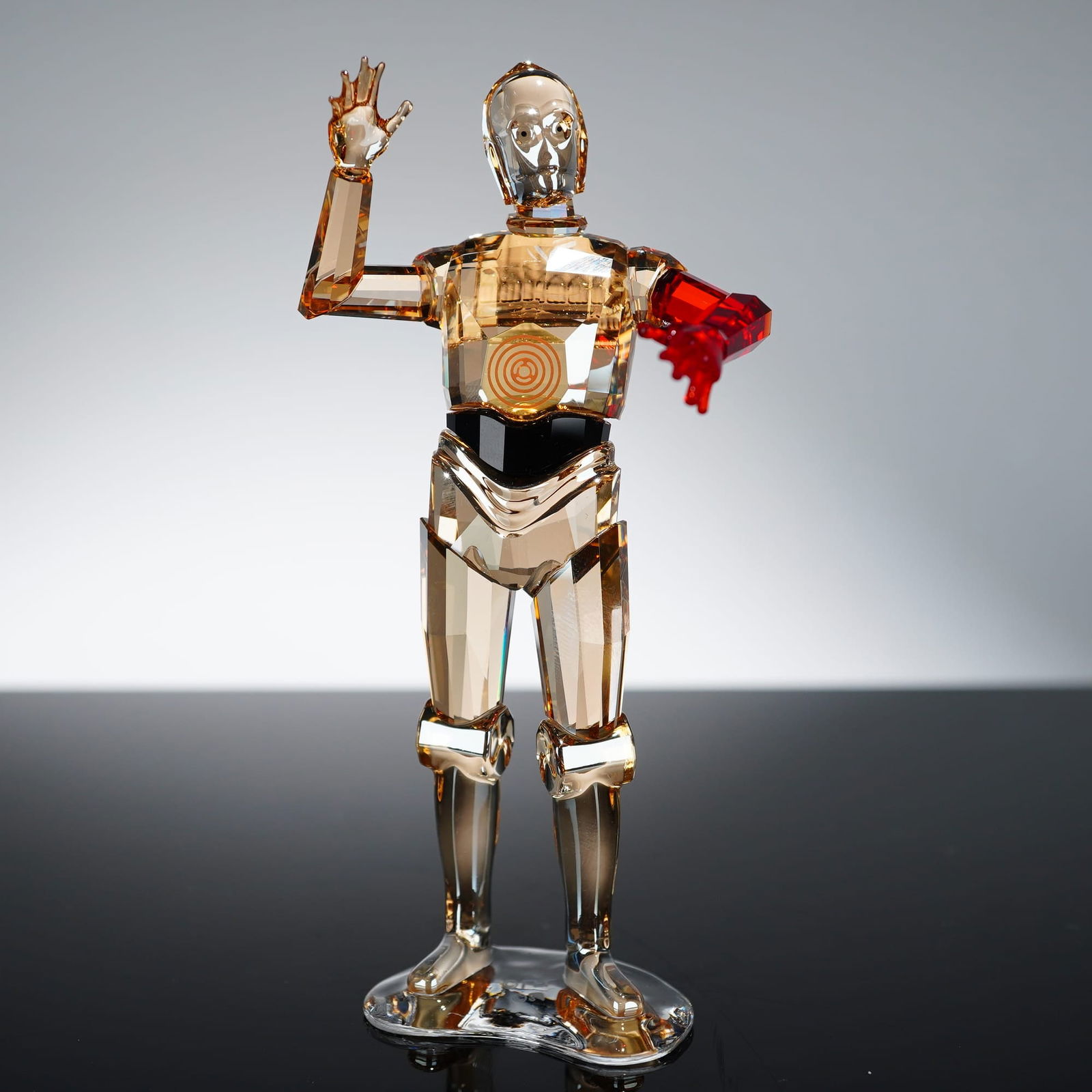 Swarovski Star Wars C-3PO Red Arm Figurine 5290214, 4.5 Inches: Swarovski Star Wars C-3PO figurine, model 5290214. This piece is crafted from golden-toned faceted crystal with a black crystal midsection and a vibrant red crystal left arm, representing the characte
