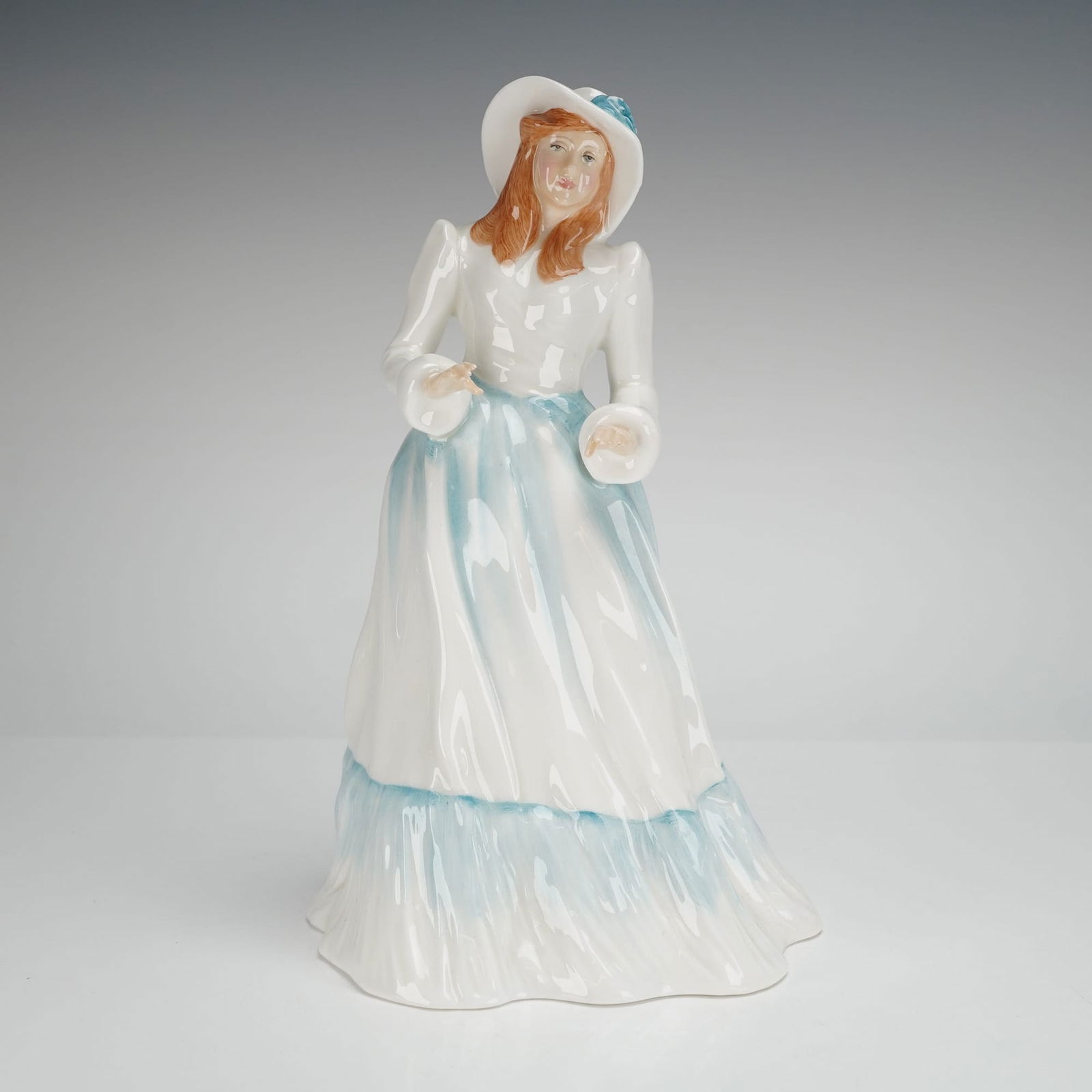 Royal Doulton Figurine Emily HN3204: Bone china figurine is part of the Vanity Fair Ladies Series, modelled by Adrian Hughes. The figure depicts a woman in a romanticized period dress and wide-brimmed hat, executed in a predominantly whi