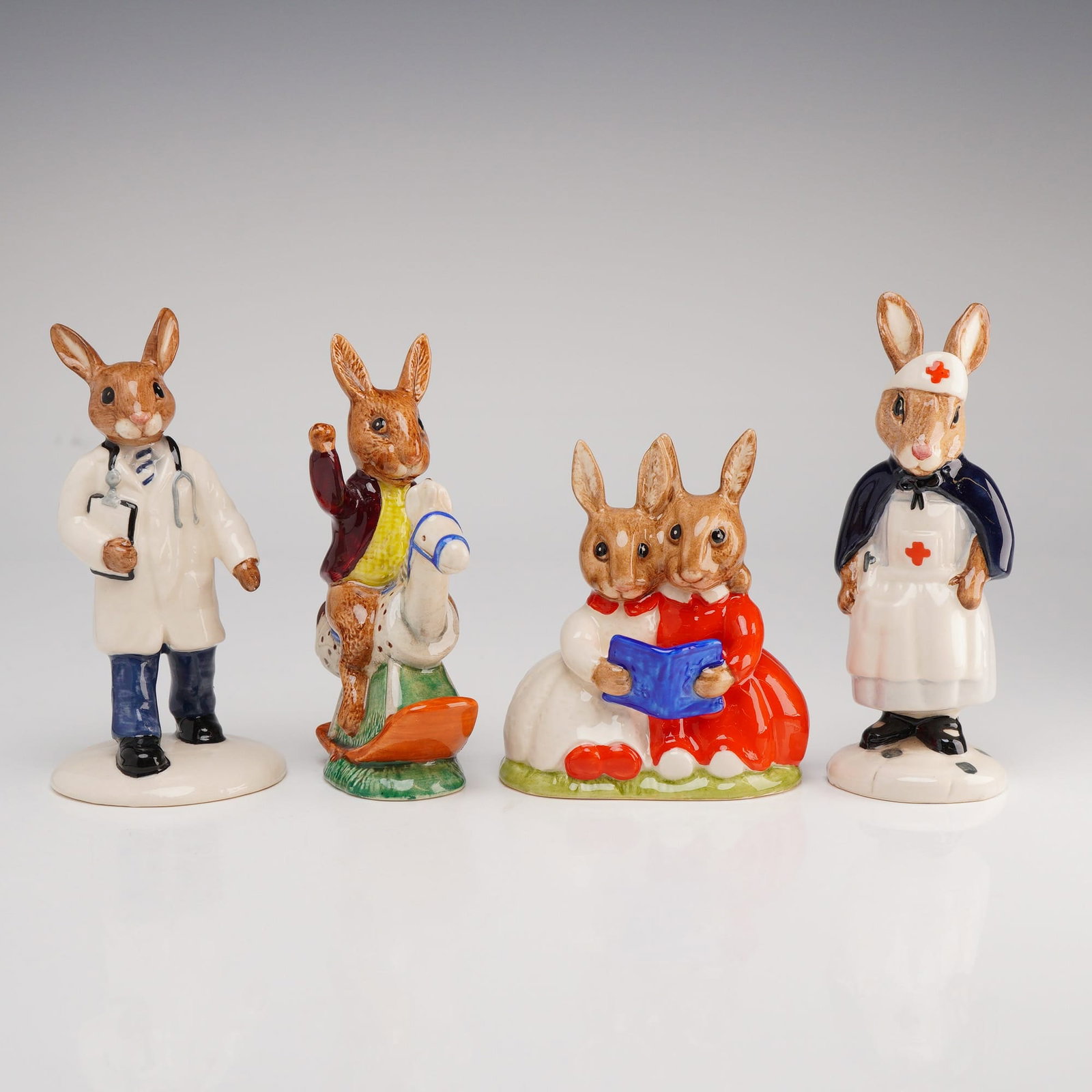 Royal Doulton Bunnykins, Tally Ho, Doctor, Nurse, & Partners in Collecting: Royal Doulton glazed ceramic figurines. Each base is marked with the official Royal Doulton backstamp, model numbers, and copyright dates. This group of four figurines includes Tally Ho (DB 12) from 1