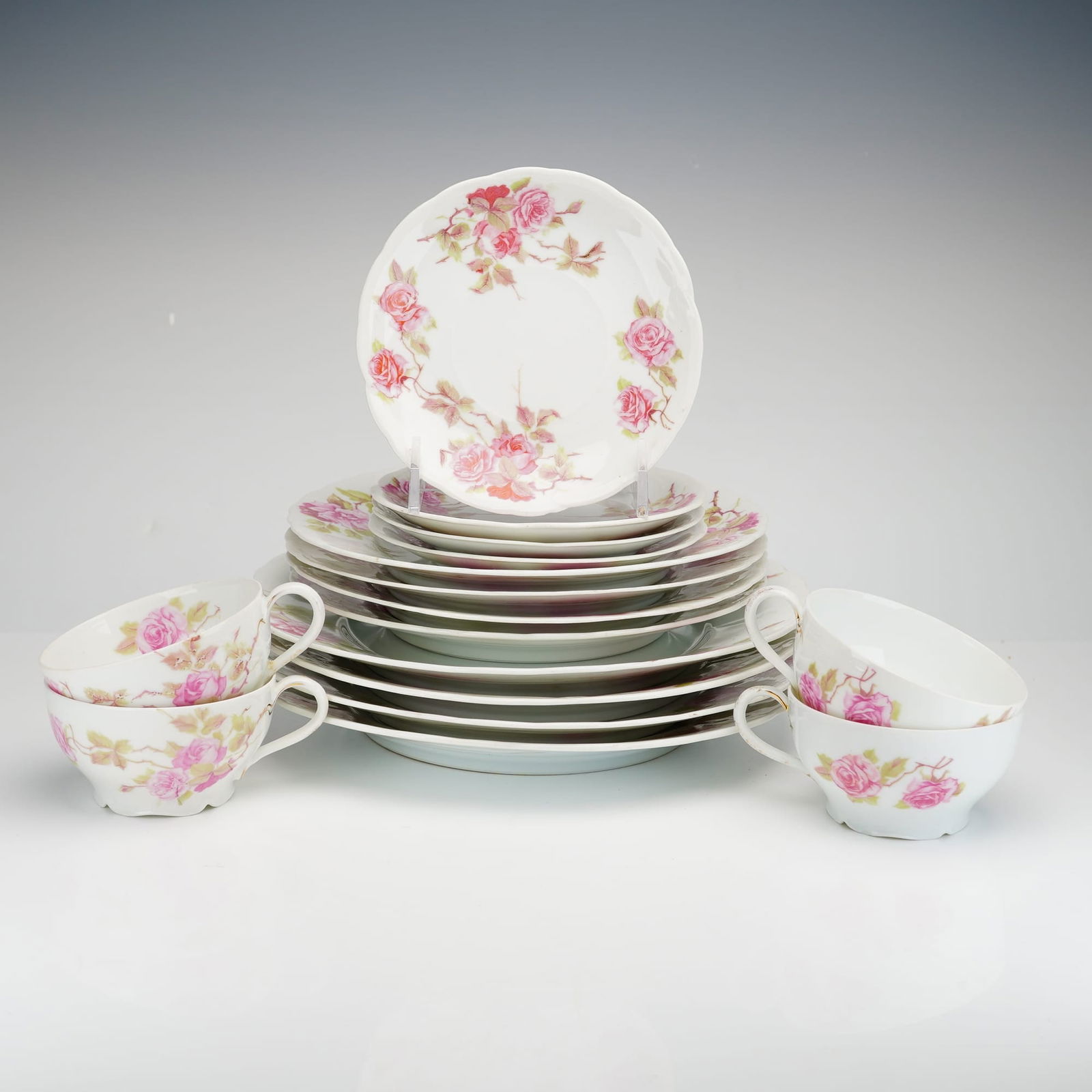 Rosenthal Iris Blank Rose Patterned 16-Piece Porcelain Tea and Luncheon Service: A sixteen-piece fine porcelain partial tea and luncheon service by Rosenthal, Bavaria. The set is produced on the "Iris" blank, characterized by organic scalloped rims and curved handles. The decorati