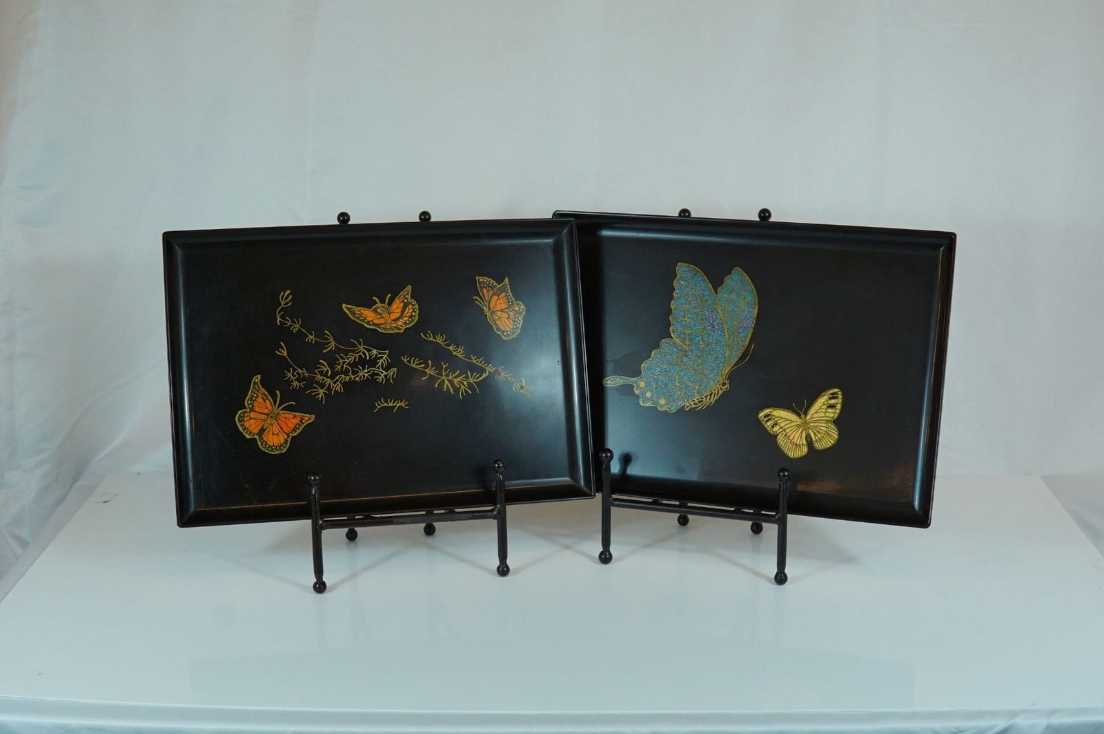 2pc Couroc of Monterey Butterfly Inlaid Serving Trays: These trays are composed of a signature satin-finish black phenolic resin, a material developed to be highly durable and resistant to heat, water, and alcohol. The decorative motifs are created using