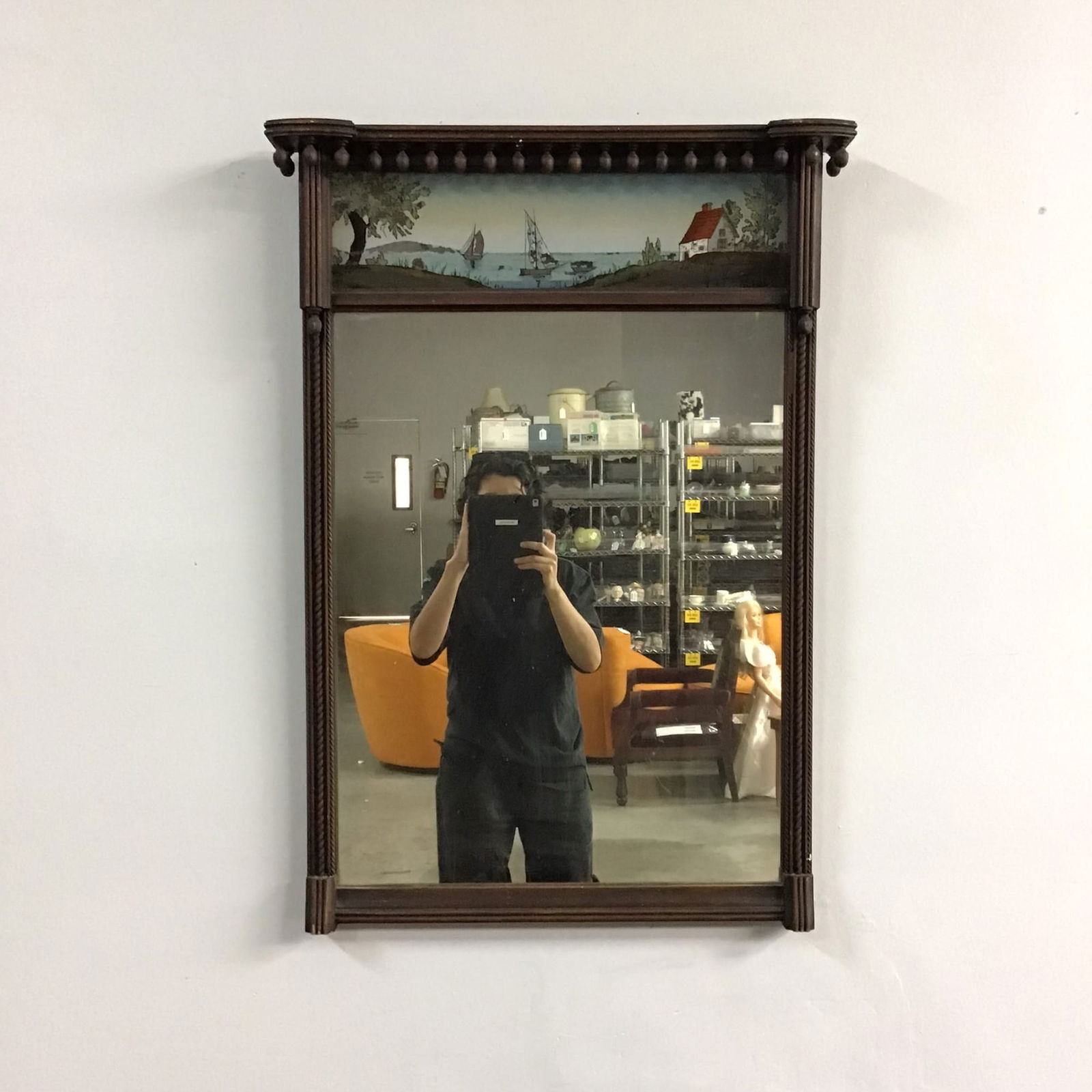 Federal Style Wood Tabernacle Mirror with Reverse Painting, 19th Century: This 19th-century American Federal style tabernacle wall mirror is constructed from a dark-stained wood frame, likely mahogany or walnut. The architectural design features a prominent overhanging corn