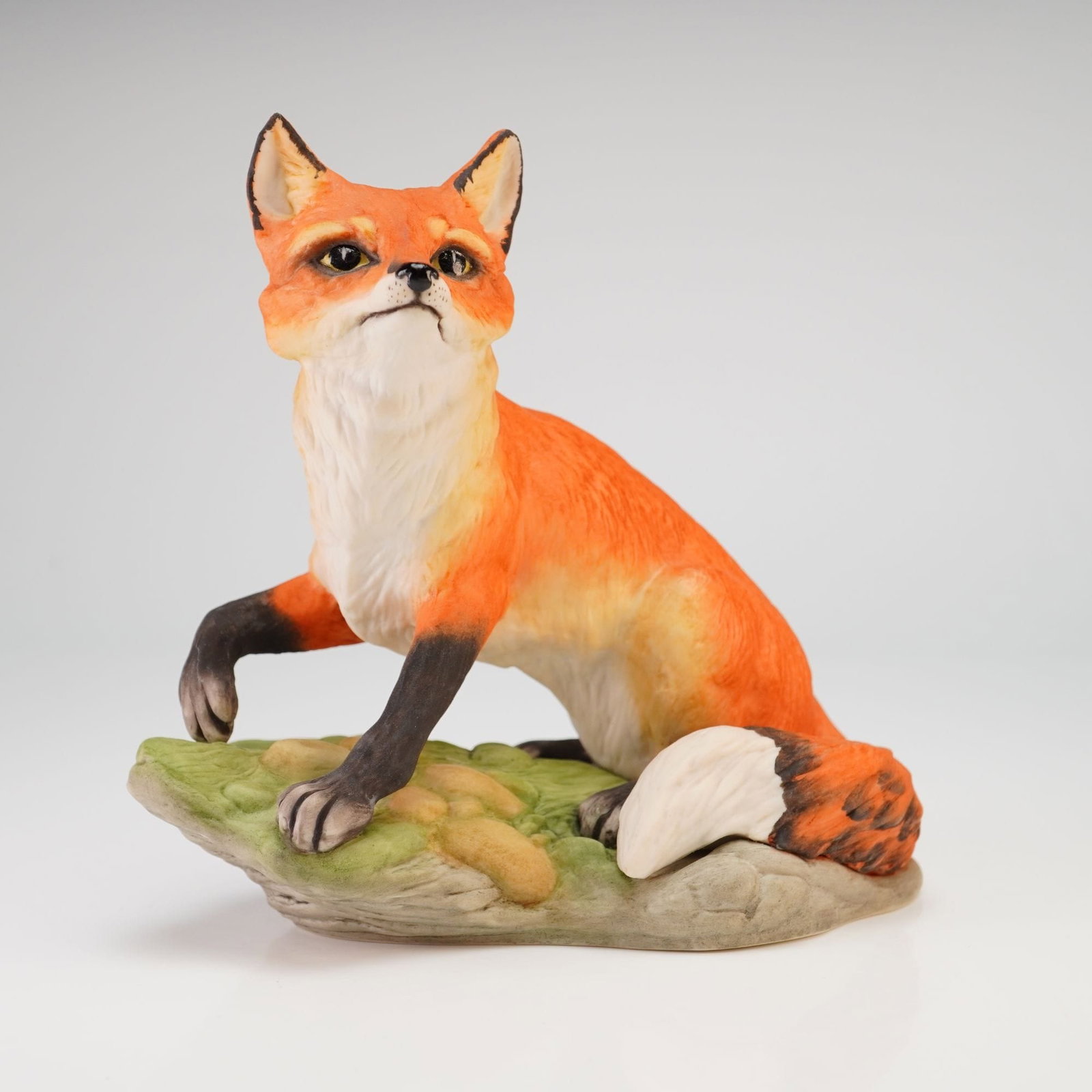Boehm Hand Painted Bisque Porcelain Fox Figurine Model 40108: A hand-painted bisque porcelain figurine of a red fox produced by the Edward Marshall Boehm studio. The animal is depicted in a seated, alert posture with the right front paw slightly raised. The fox