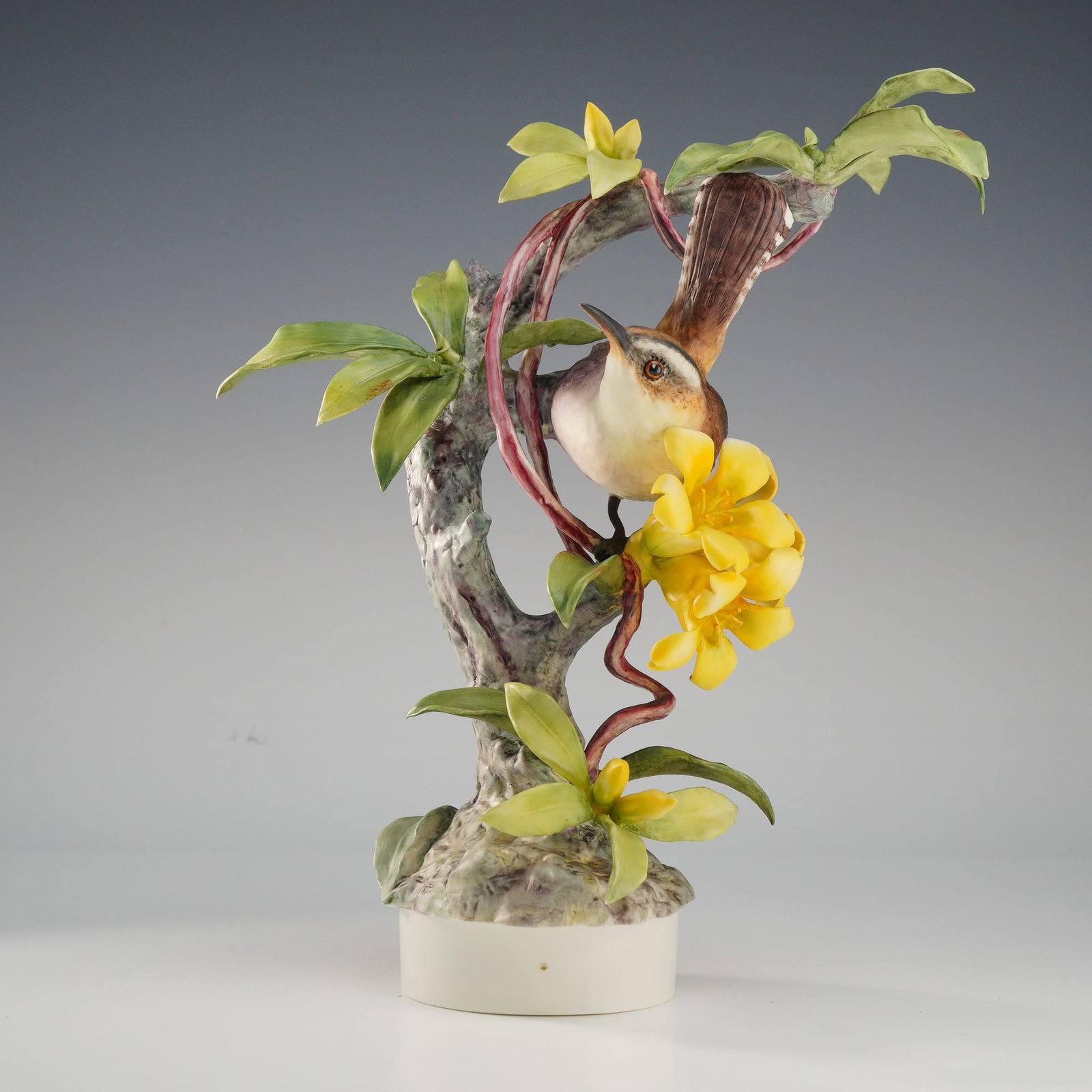 Royal Worcester Dorothy Doughty Porcelain Figurine, Bewick's Wren: This Royal Worcester bird figurine, designed by Dorothy Doughty, depicts a Bewick's Wren (Thryomanes bewickii) perched on a branch of yellow jasmine. This matte bisque porcelain sculpture is part of t