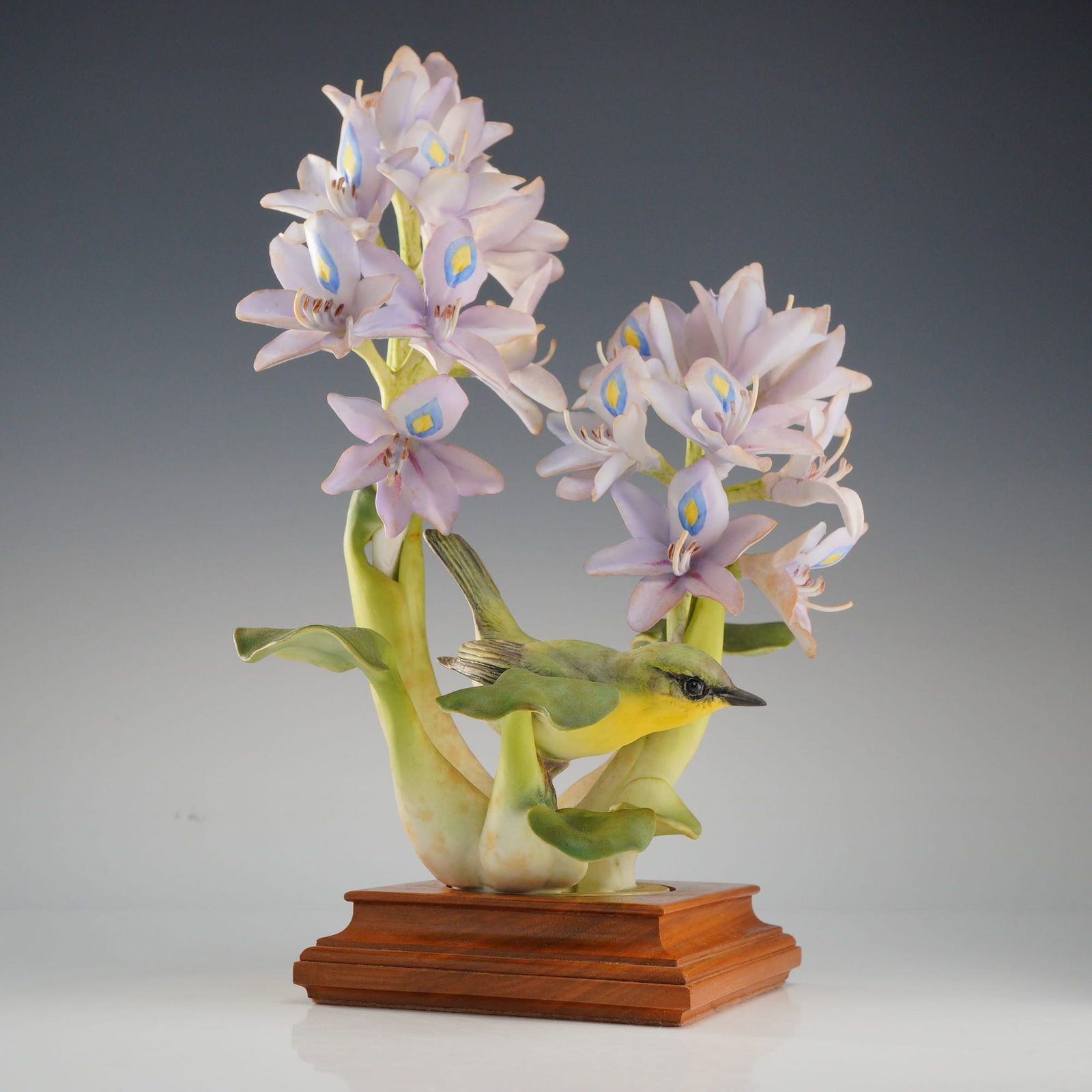Royal Worcester Sculpture, Yellow Throat Geothlypis Trichas: Yellow Throat Geothlypis Trichasis perched on lavender Water Hyacinth, Signed on base and sits in fitted wood base. Designed by Dorothy Doughty for the American Bird Series. Royal Worcester backstamp