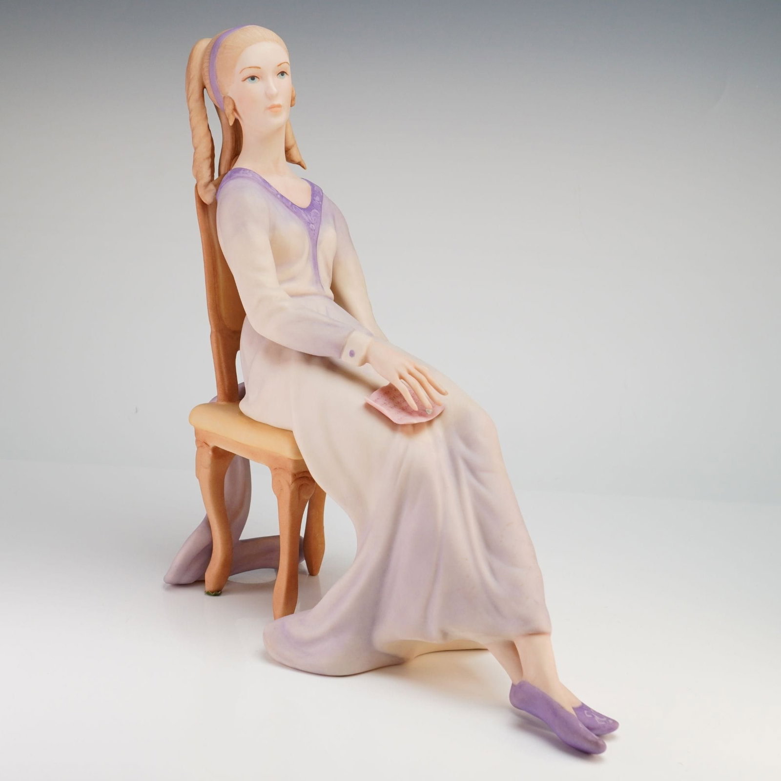 Laszlo Ispanky Prudence with Roses Limited Edition Porcelain Figurine: A matte-finished bisque porcelain figurine titled Prudence, also known as Prudence with Roses, by artist Laszlo Ispanky for Ispanky Porcelains. The sculpture depicts a slender woman seated in a high-b