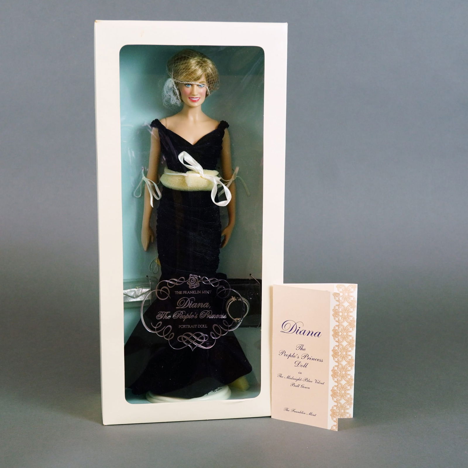 The Franklin Mint Diana The People's Princess Portrait Doll, 18 Inches: This vinyl portrait doll was produced by The Franklin Mint as part of a hand-numbered Portrait Edition. The doll features stationary painted blue eyes and a styled blonde synthetic wig in the iconic h