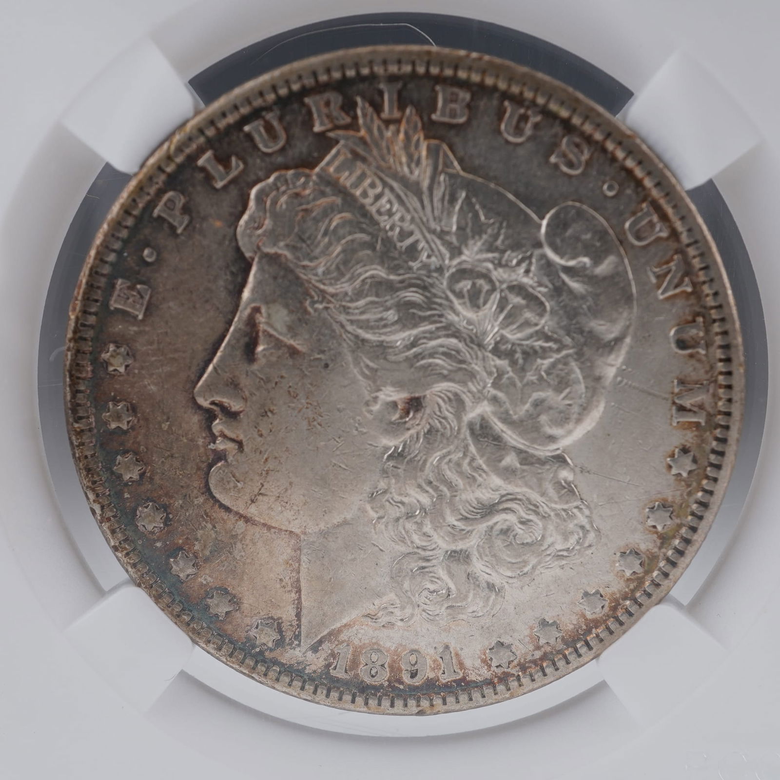 1891 Morgan Silver Dollar: An 1891 Morgan Silver Dollar, struck in ninety percent silver and ten percent copper. The obverse features George T. Morgan's allegorical portrait of Liberty wearing a Phrygian cap adorned with wheat