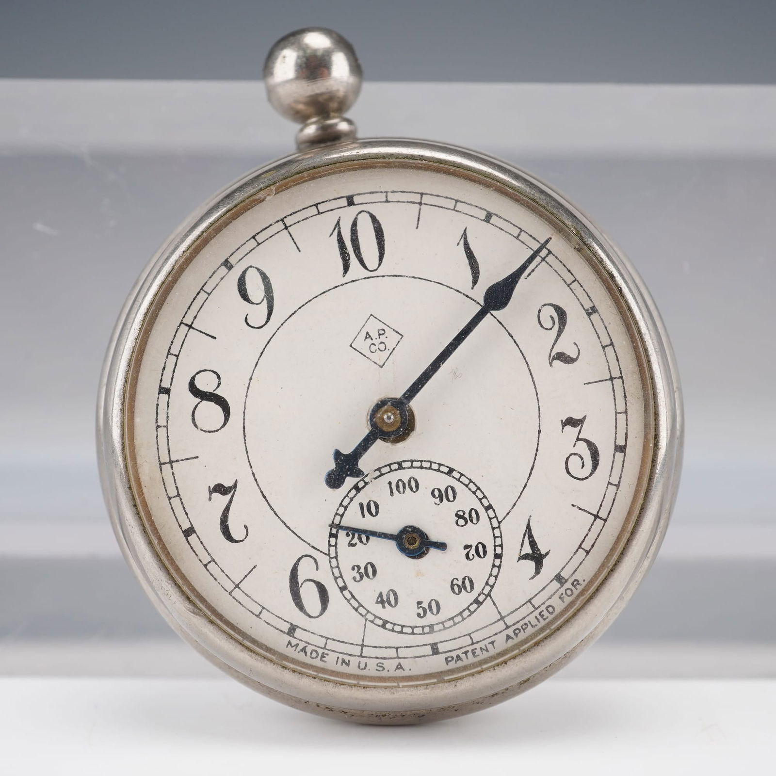 American Pedometer Co. Pocketwatch-Style Pedometer: An American Pedometer Co. pocketwatch?style pedometer with silver?tone case, white dial, black Arabic numerals, blue steel hands, sub?dial 10–100. Marked A.P. Co. MADE IN U.S.A. and PATENT APPLIED F