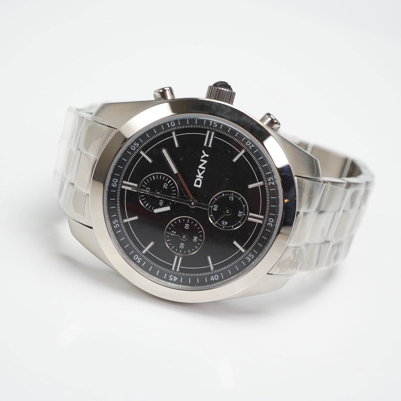 DKNY NY-1246 Men's Stainless Steel Chronograph Watch: A DKNY NY-1246 Men's Chronograph watch constructed of solid stainless steel. The modern timepiece features a round case housing a black dial with baton indices and three subsidiary dials for the chron
