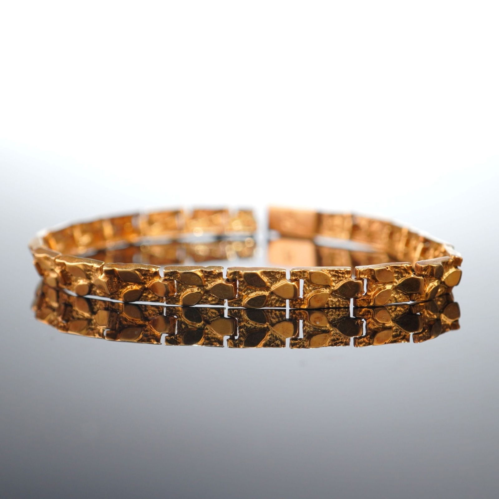 14K Italian Yellow Gold Nugget Link Bracelet: Crafted from 14K yellow gold, this bracelet features flat, patterned nugget style panel links. Box clasp with a safety catch closure. Marked 14K Italy on the clasp. Dimensions7.5"L Weight10.4g