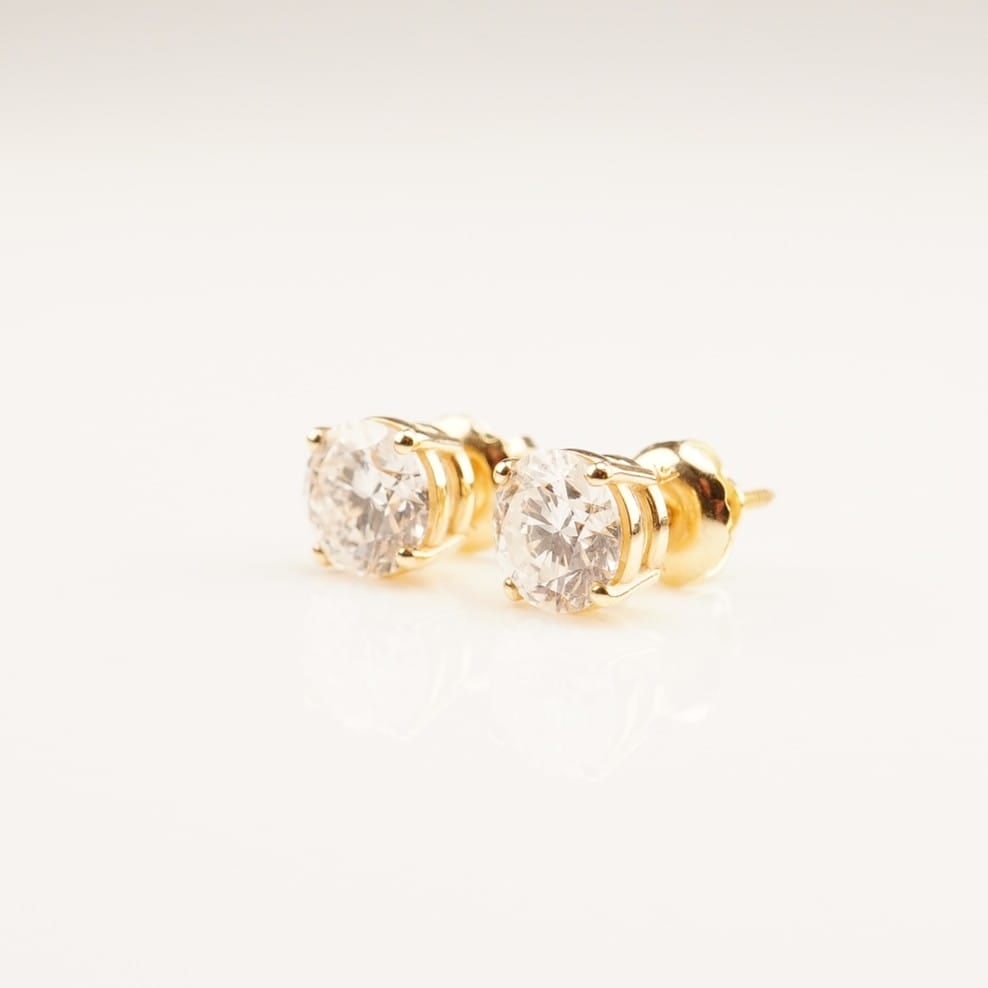 14K Gold 1.55ctw Diamond Stud Earrings: A pair of yellow gold screw-back stud earrings featuring round lab-grown diamonds, each set in a four-prong setting. The diamonds are E color with VS1 clarity, with a total combined weight of 1.55 car