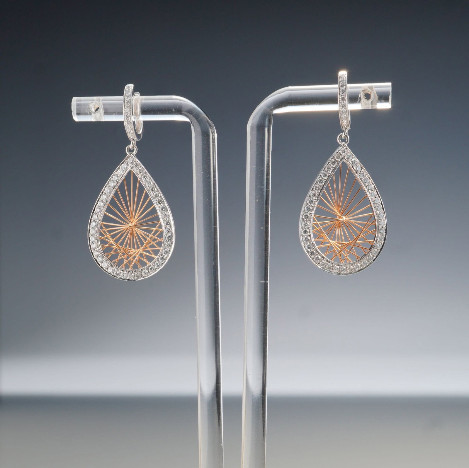 Pair of 14K Two-Tone Gold 1.10ctw Diamond Teardrop Dangle Earrings: A striking pair of 14K two-tone gold dangle earrings featuring teardrop-shaped drops outlined in white gold and accented with round white diamonds totaling approximately 1.10 carats. The intricate inn