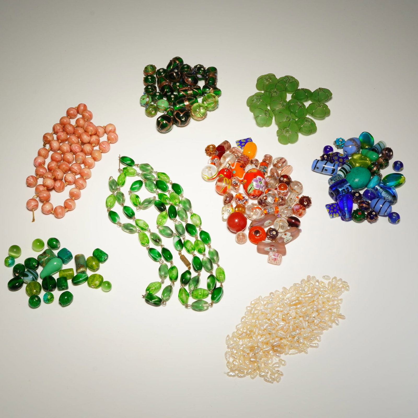 Assorted Beaded Costume Jewelry and Loose Beads: This lot features a comprehensive collection of costume jewelry and loose components. Included is a multi-strand necklace featuring green and white marbled oval glass beads connected by metal wire lin