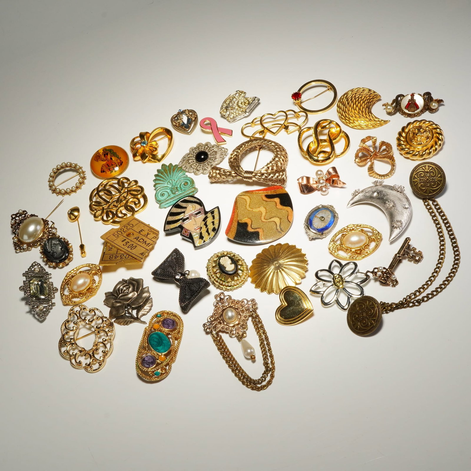 Assorted Gold-Tone and Silver-Tone Mixed Motif Costume Jewelry Brooches: This collection of approximately 40 costume jewelry brooches and pins features a variety of vintage and contemporary designs. Notable motifs include an enameled Art Deco-revival woman's profile, a sil