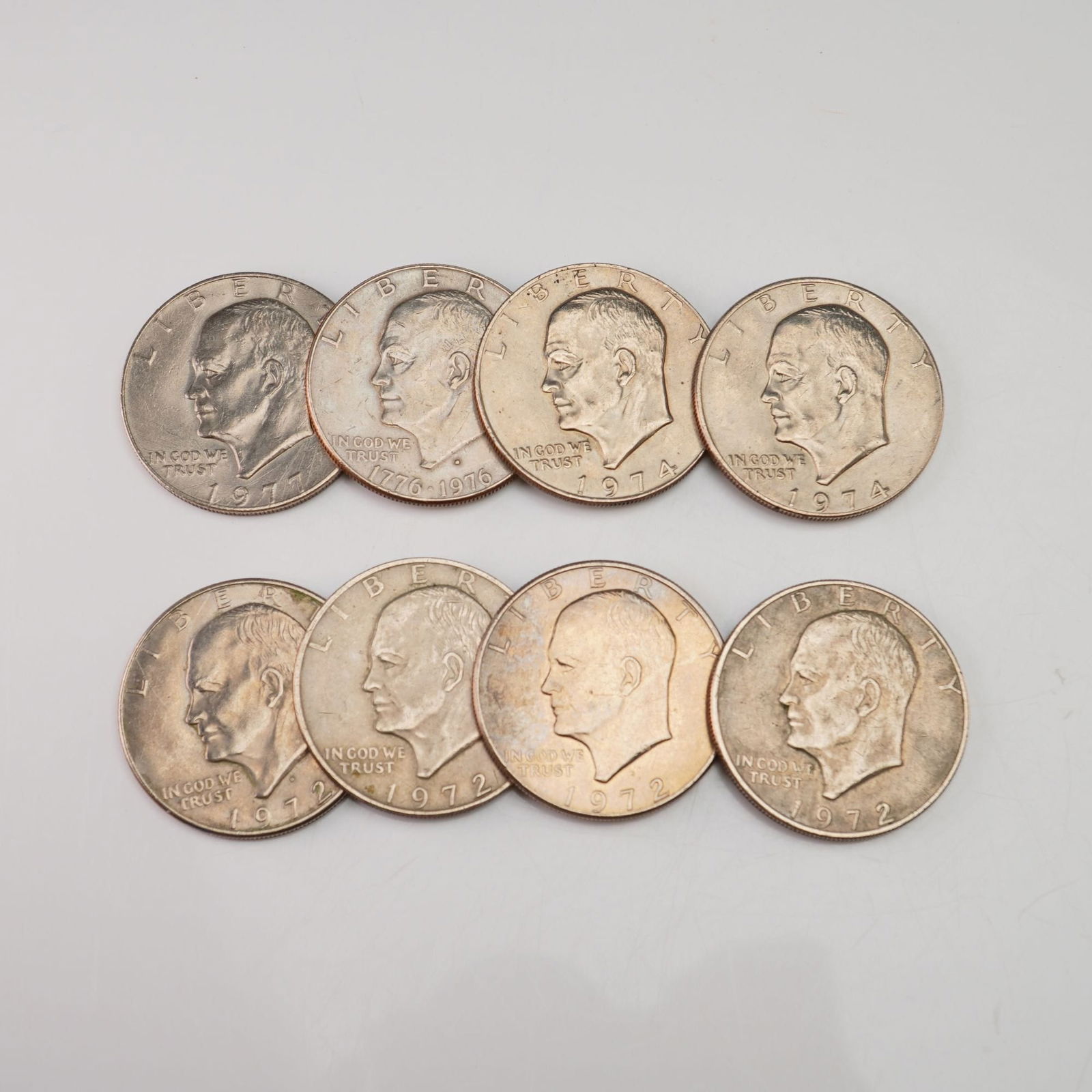 1972, 1974, 1976, 1977 Eight Eisenhower One Dollar Circulated Coins: Minted by Philadelphia Mint. The obverse depicts a bust of Dwight D. Eisenhower facing left with the date below. The reverse depicts Apollo 11 Mission Insignia (an eagle holding an olive branch flying