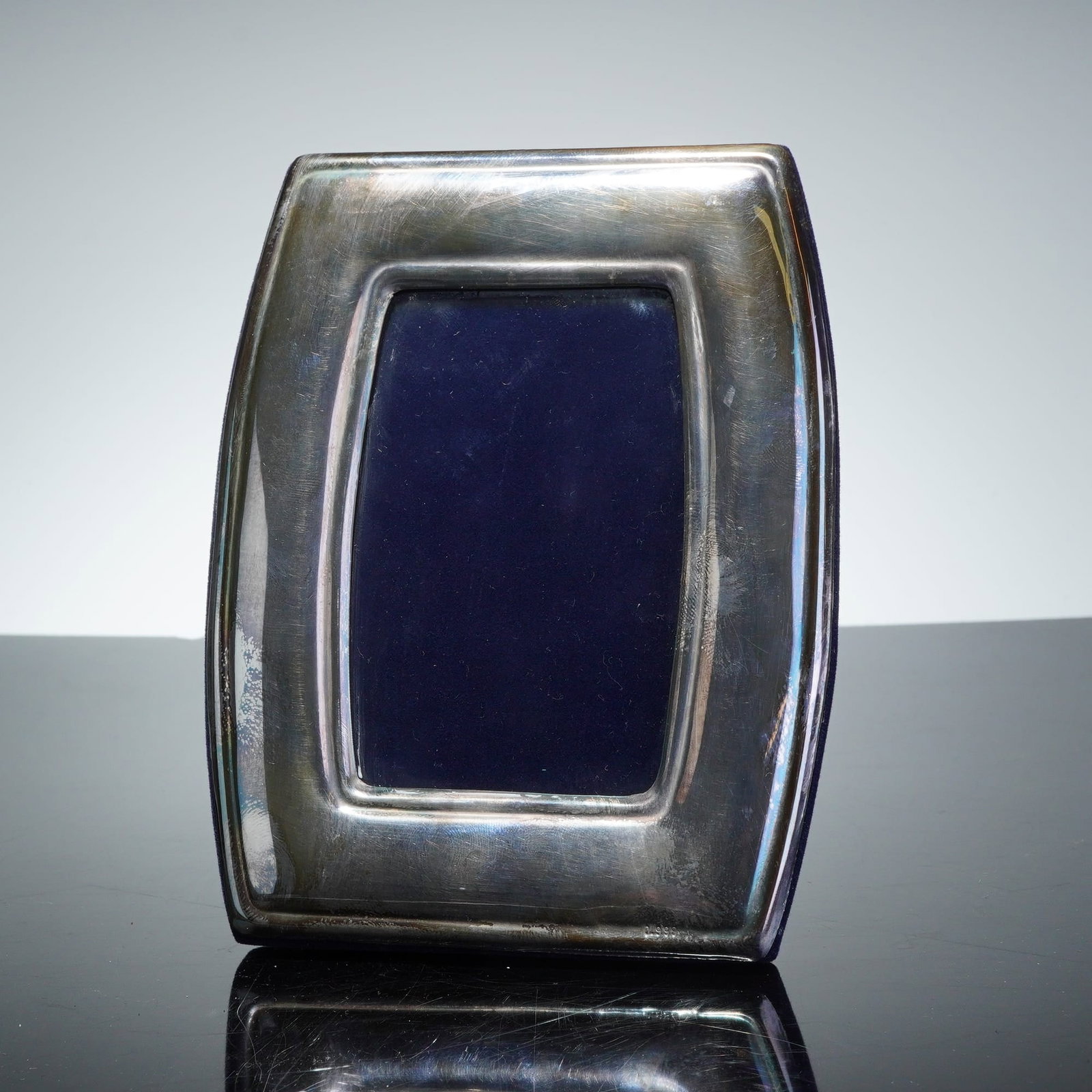Atenea Orfebreria Fine Silver Tonneau Picture Frame: This fine silver picture frame is produced by Atenea Orfebreria of Bogota, Colombia. The object features a tonneau-shaped form with a polished face and slightly bowed sides. The construction consists