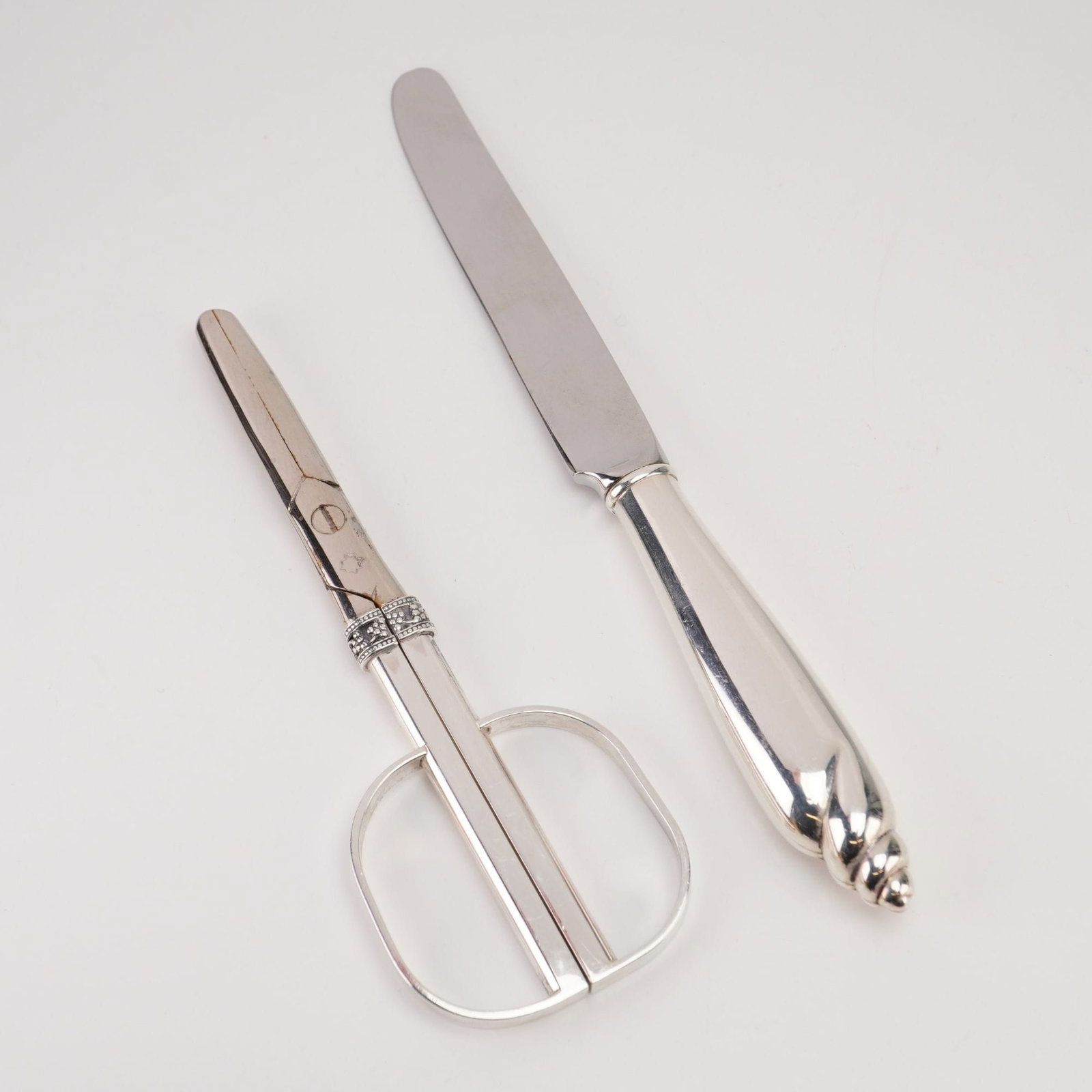 Angela Cummings, Shell Pattern, Two-Piece Desk Set, Sterling Silver: A pair of sterling silver desk accessories by designer Angela Cummings, circa 1985. The set comprises a letter opener and a pair of scissors. The letter opener features a handle terminating in a sculp