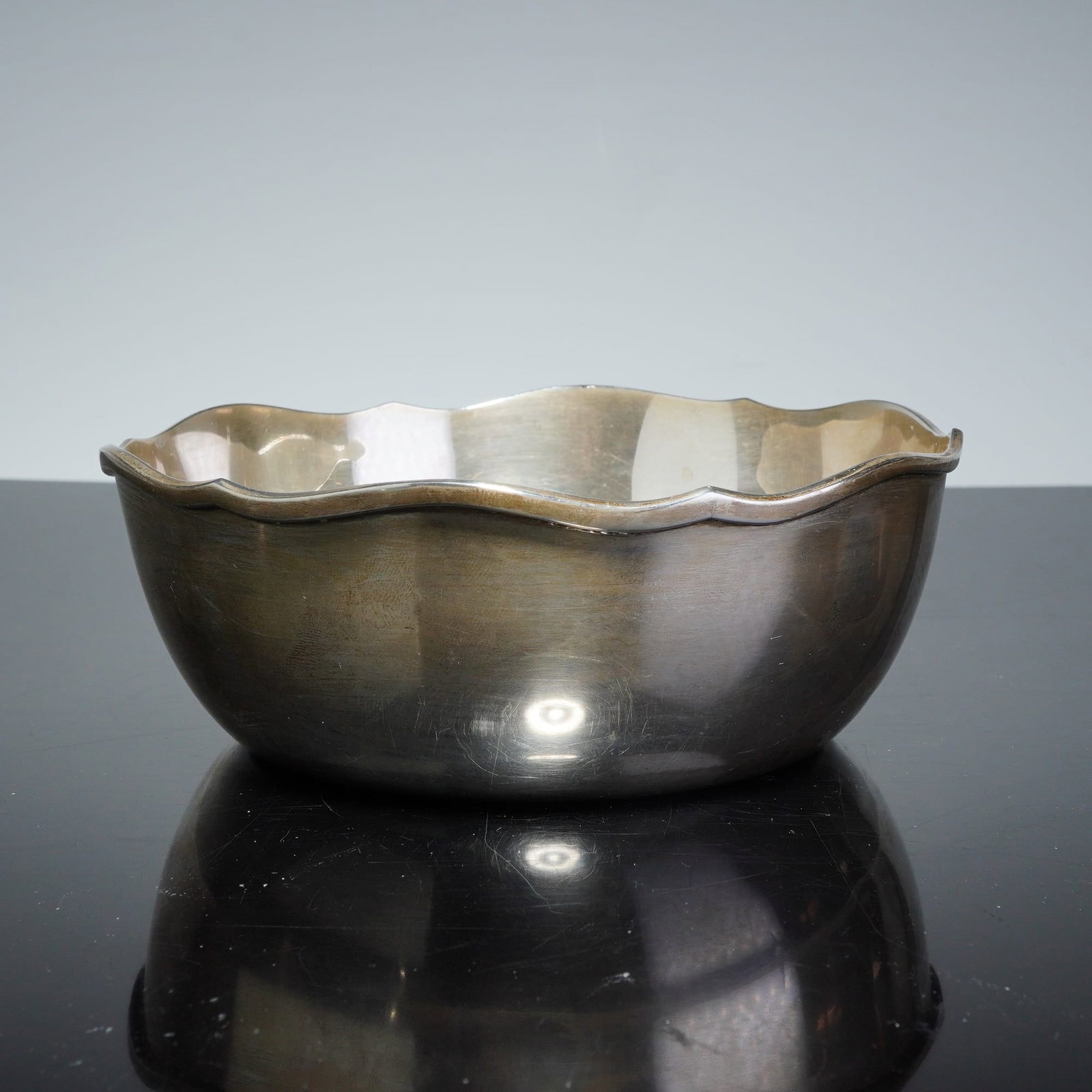 Scandinavian Silver Scalloped Rim Bowl: A silver bowl featuring a rounded body and a scalloped rim. The piece is constructed from silver, a standard fineness common in Scandinavian silver production. The underside of the base is stamped wit