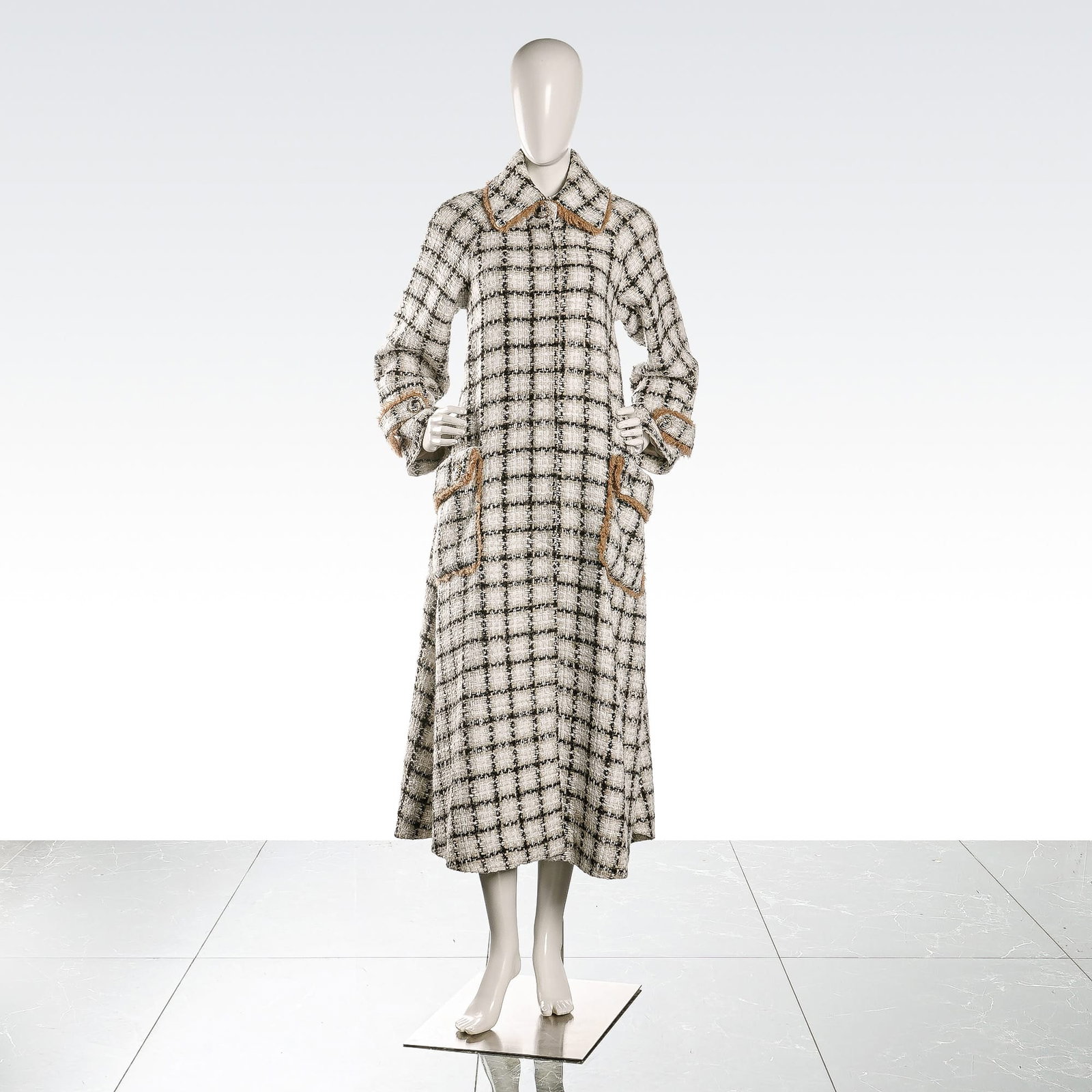 Chanel Plaid Wool Tweed Fringe Trim Coat: A Chanel long-length coat featuring a black and white checked plaid pattern in a textured boucle-style wool weave. The garment is designed with a pointed collar, long sleeves, and two large front patc