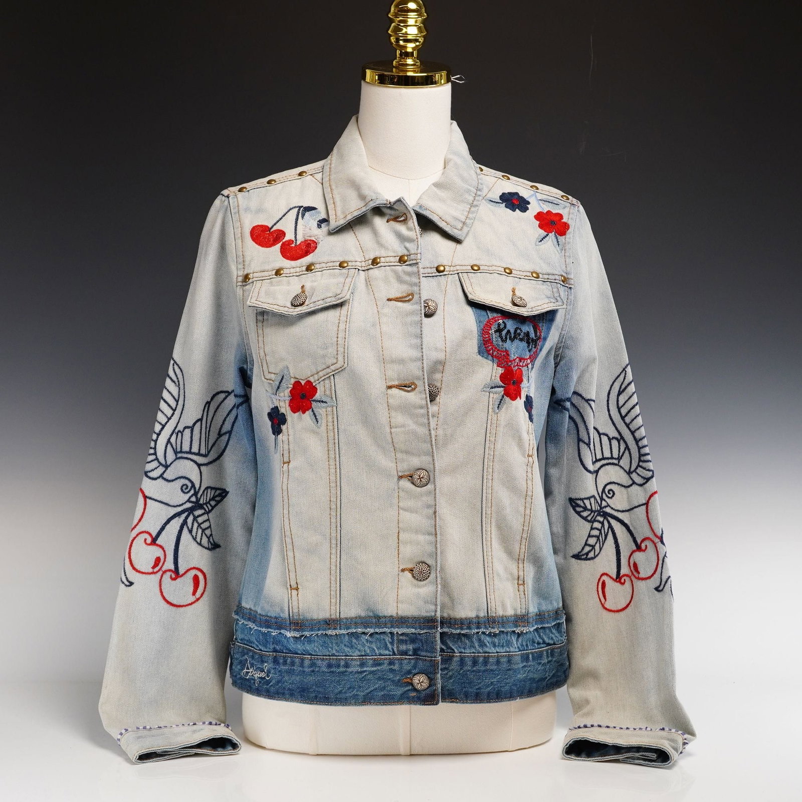 21st Century Desigual Embroidered and Studded Two-Tone Denim Trucker Jacket: This contemporary Desigual women’s trucker-style denim jacket features a 1970s-inspired bohemian aesthetic. The garment is constructed from mid-weight cotton denim in a two-tone composition, featuri
