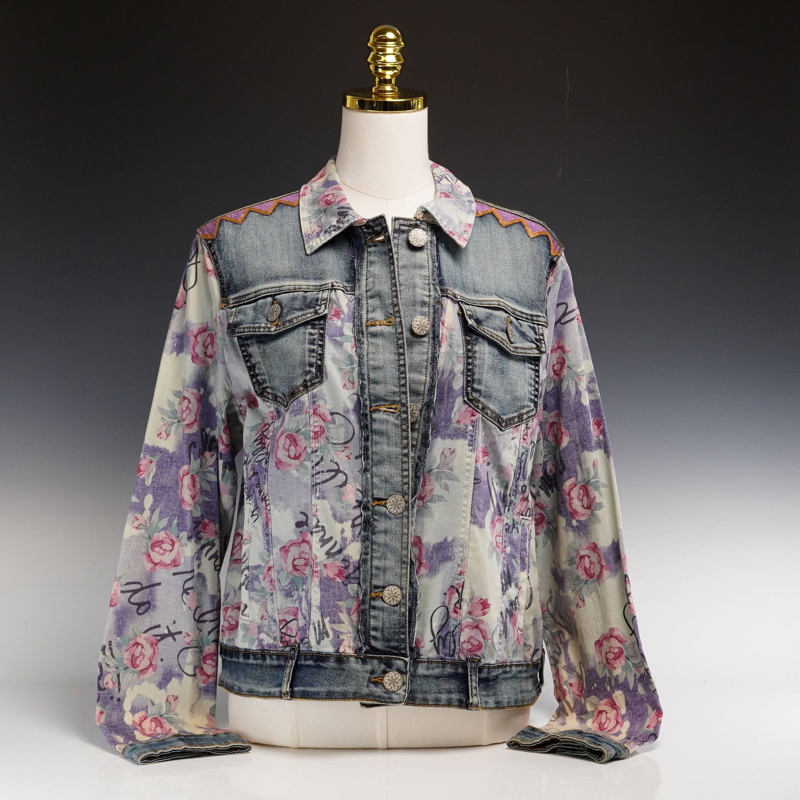 Contemporary Desigual Denim Jacket with Floral Embroidery: This is a contemporary trucker-style mixed-media denim jacket by the Spanish brand Desigual. The garment is constructed from medium-weight cotton denim featuring a combination of traditionally dyed, f
