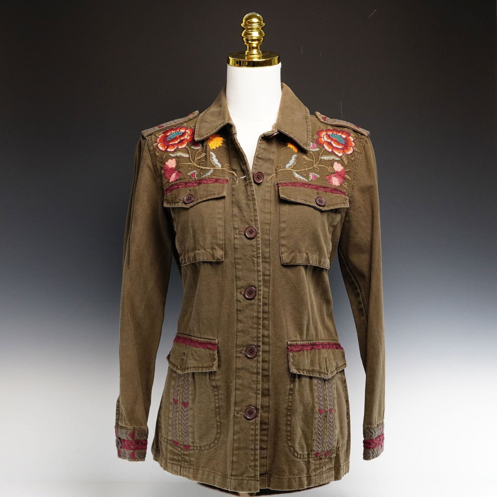 Contemporary Johnny Was Workshop Military Style Jacket with Floral Embroidery: This contemporary Johnny Was Workshop military style jacket is designed in a bohemian-military revival aesthetic, reminiscent of 1970s utility wear. Crafted from a durable, heavyweight cotton twill in