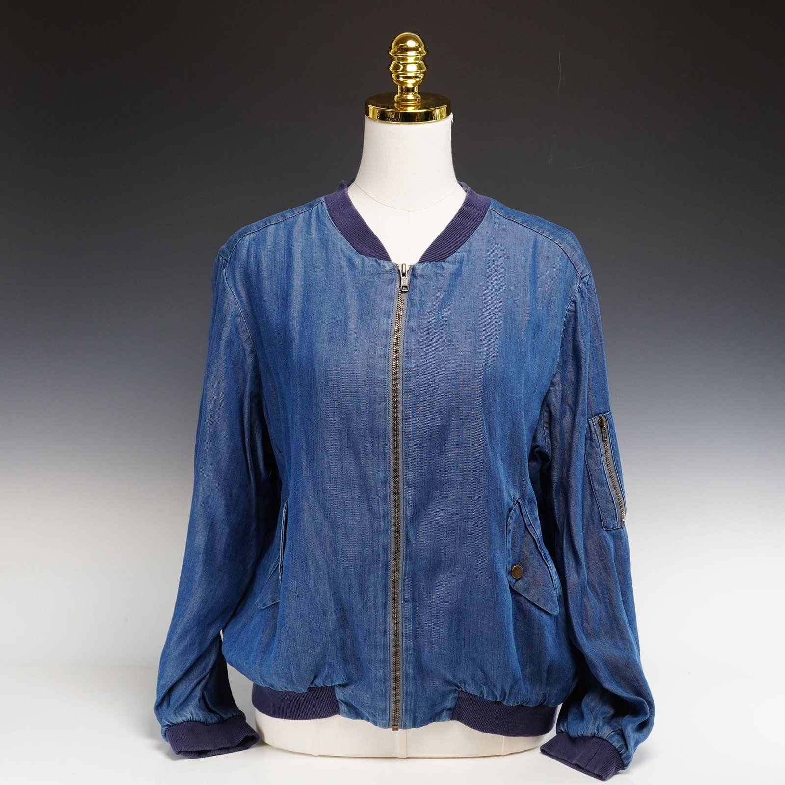Modern Johnny Was Workshop Denim Bomber Jacket with Desert Embroidery: This contemporary MA-1 inspired bomber jacket is a product of the Johnny Was Workshop label. Crafted from a soft, lightweight blue chambray-style denim, the garment features a classic blouson silhouet