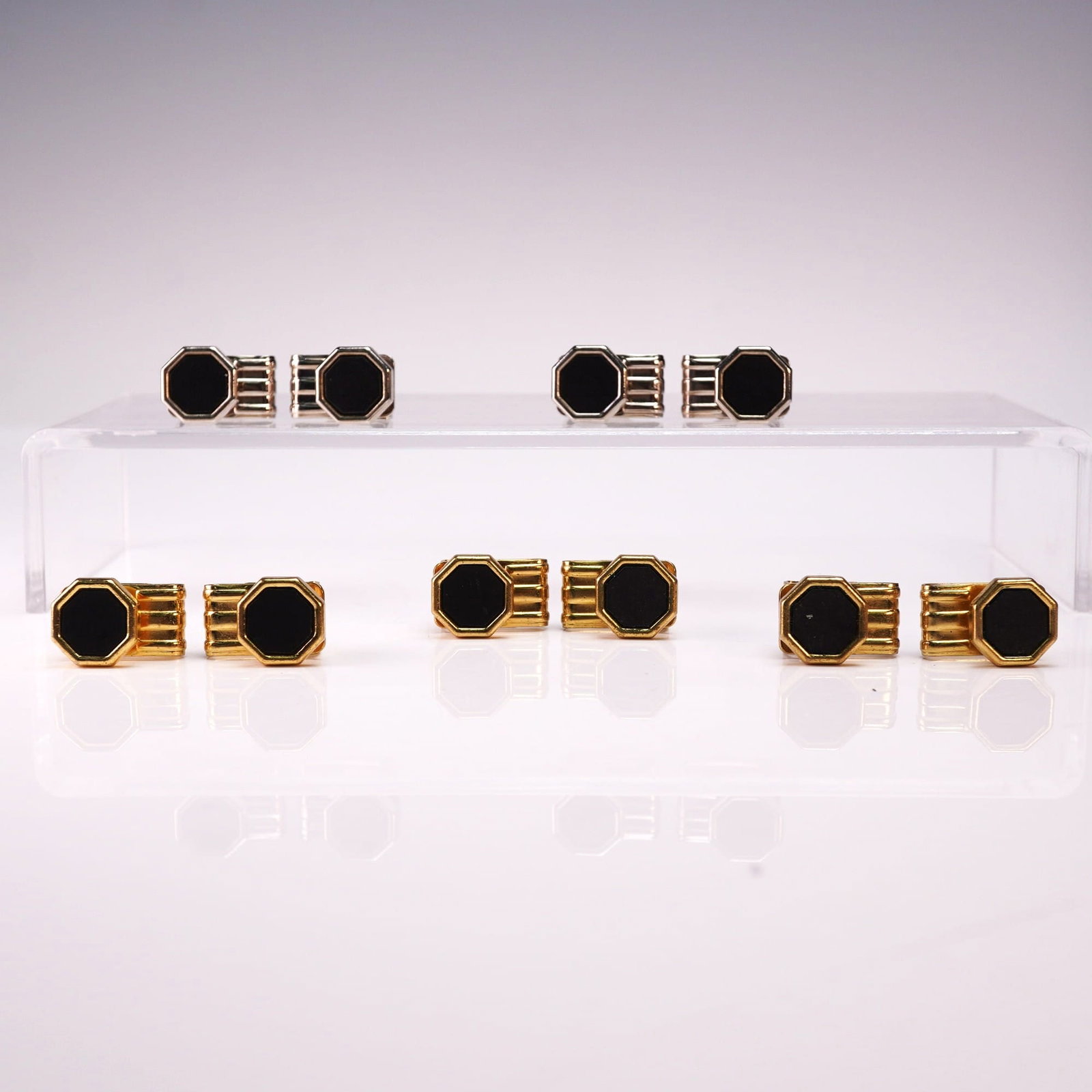5 Pairs Bracetac Gold and Silver Tone Cufflinks with Black Enamel: A collection of five pairs of handsome Bracetac cufflinks featuring bold octagonal black enamel faces framed in both gold and silver tone settings. Each pair showcases a ribbed design along the sides,