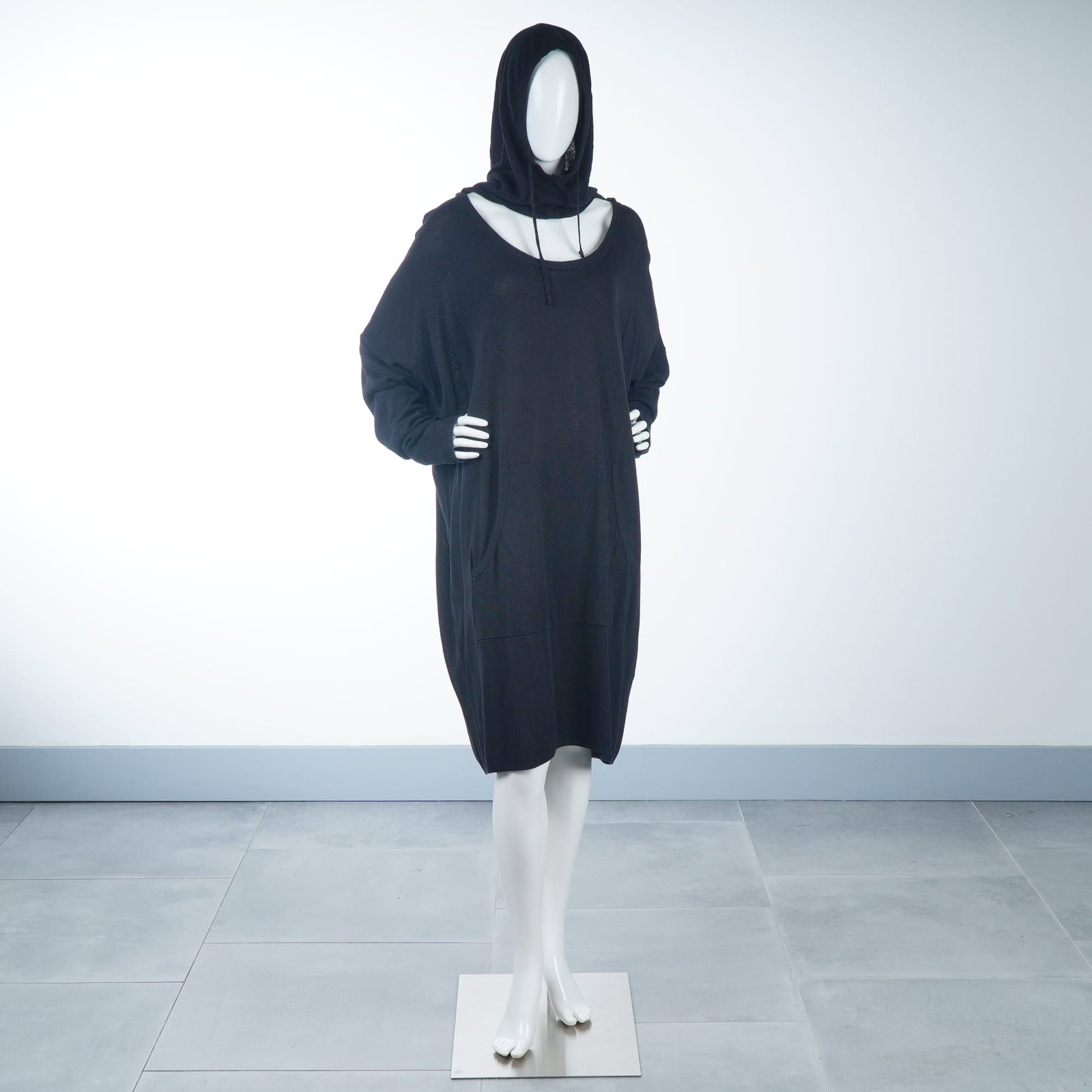Nicholas K Fabian Oversized Hooded Sweater Dress in Black Fine-Gauge Knit: This Nicholas K Fabian sweater dress is crafted from a black fine-gauge knit material. The garment features an avant-garde, oversized silhouette characterized by a wide scoop neckline and a draped, in