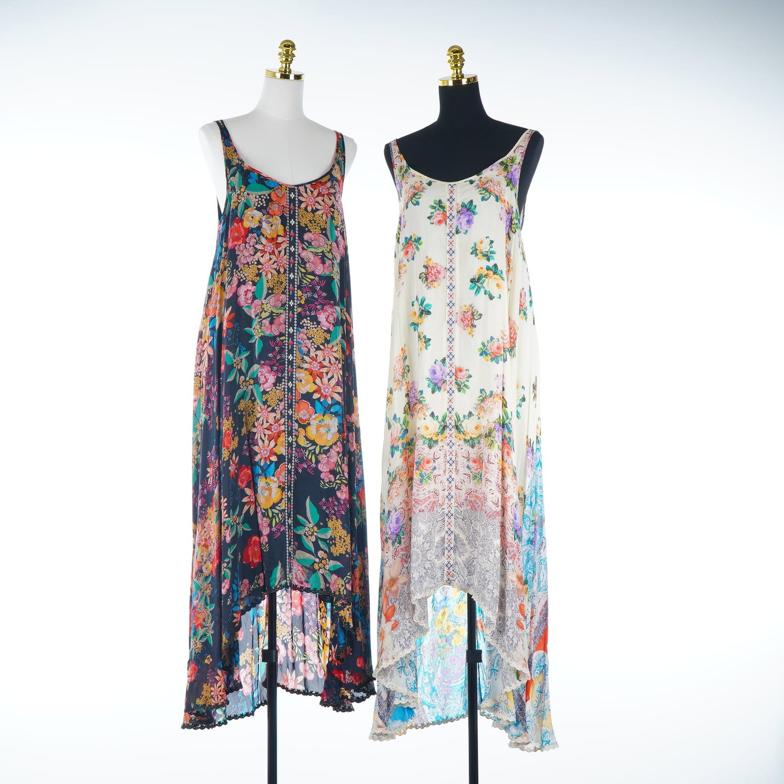 2pc Johnny Was Lined Logan High-Low Maxi Dresses Floral & Paisley Prints: Two Johnny Was sleeveless high-low maxi dresses in the Logan style, crafted from a lightweight fabric and fully lined for a smooth silhouette. The first dress features a black ground with a vibrant, m