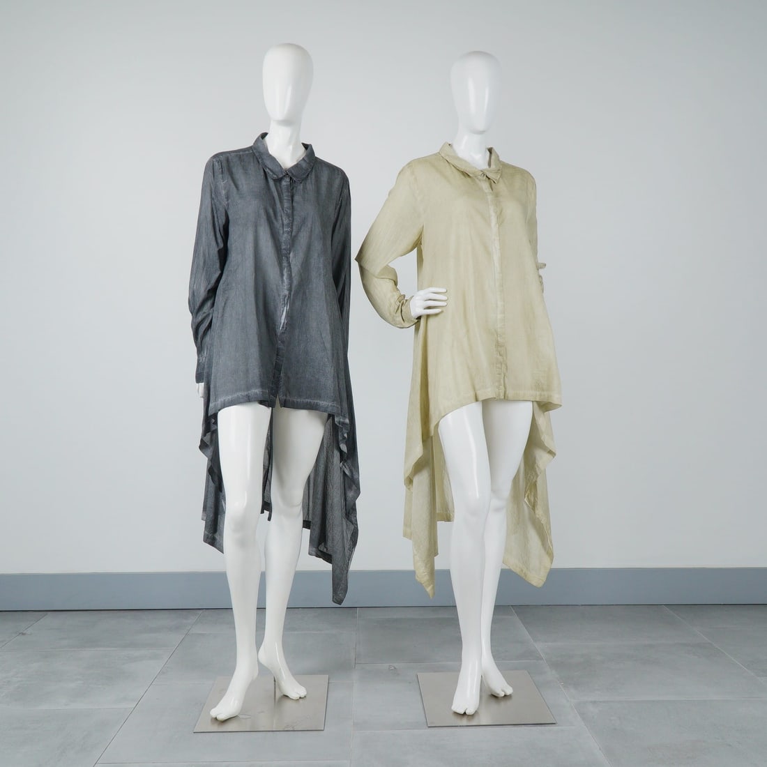 2pc Nicholas K High-Low Tunic Shirts in Sand and Black: This lot by Nicholas K features two long-sleeve tunic-style shirts characterized by a dramatic high-low silhouette. The set includes one tunic shirt in a sand color and one in black. Both garments are