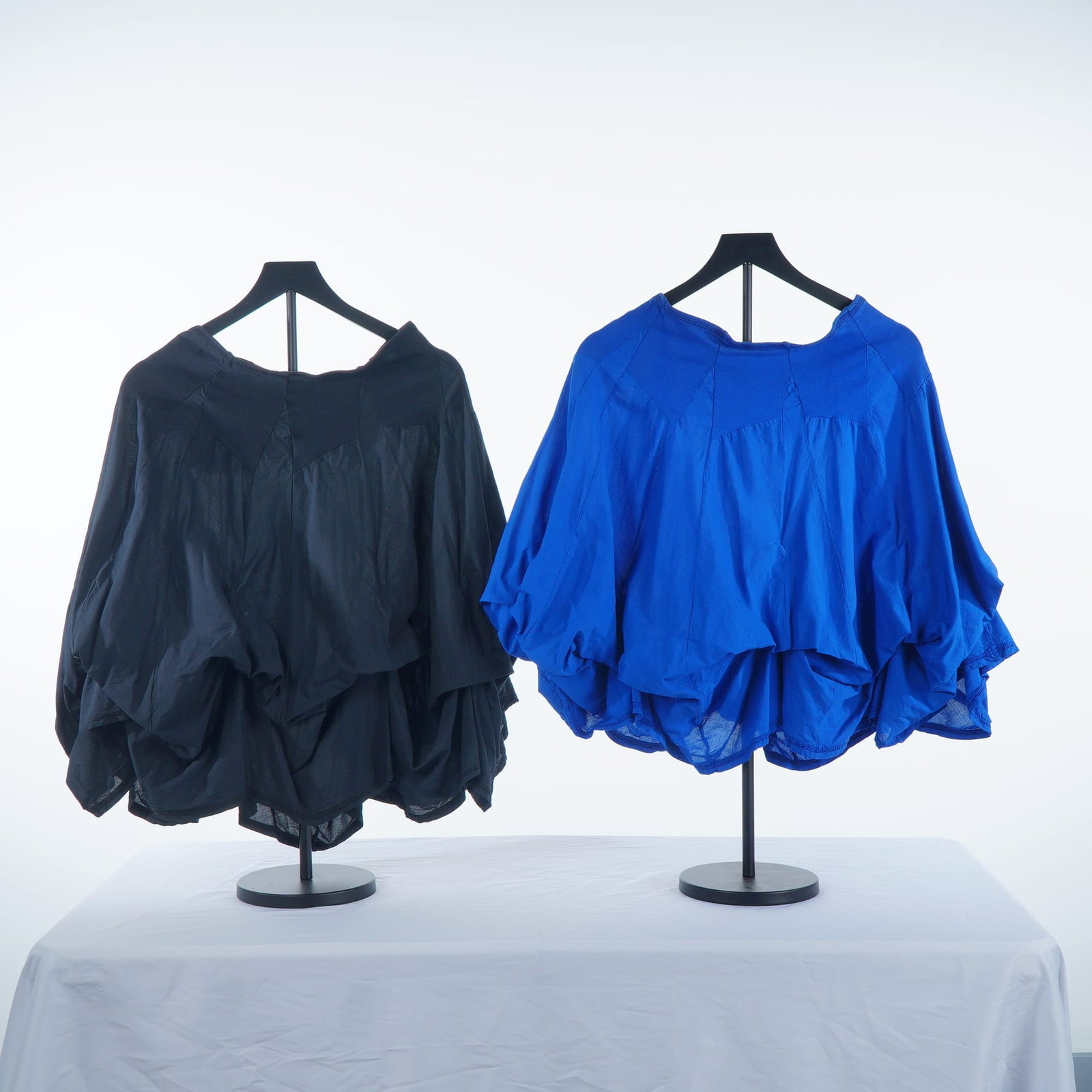 2pc Luna Luz Kiki Island Royal Blue and Black Parachute Skirts: This lot consists of two Kiki Island style parachute skirts by designer Luna Luz, featuring one in royal blue and one in black. Each garment is designed with a wide, elasticated jersey-knit waistband