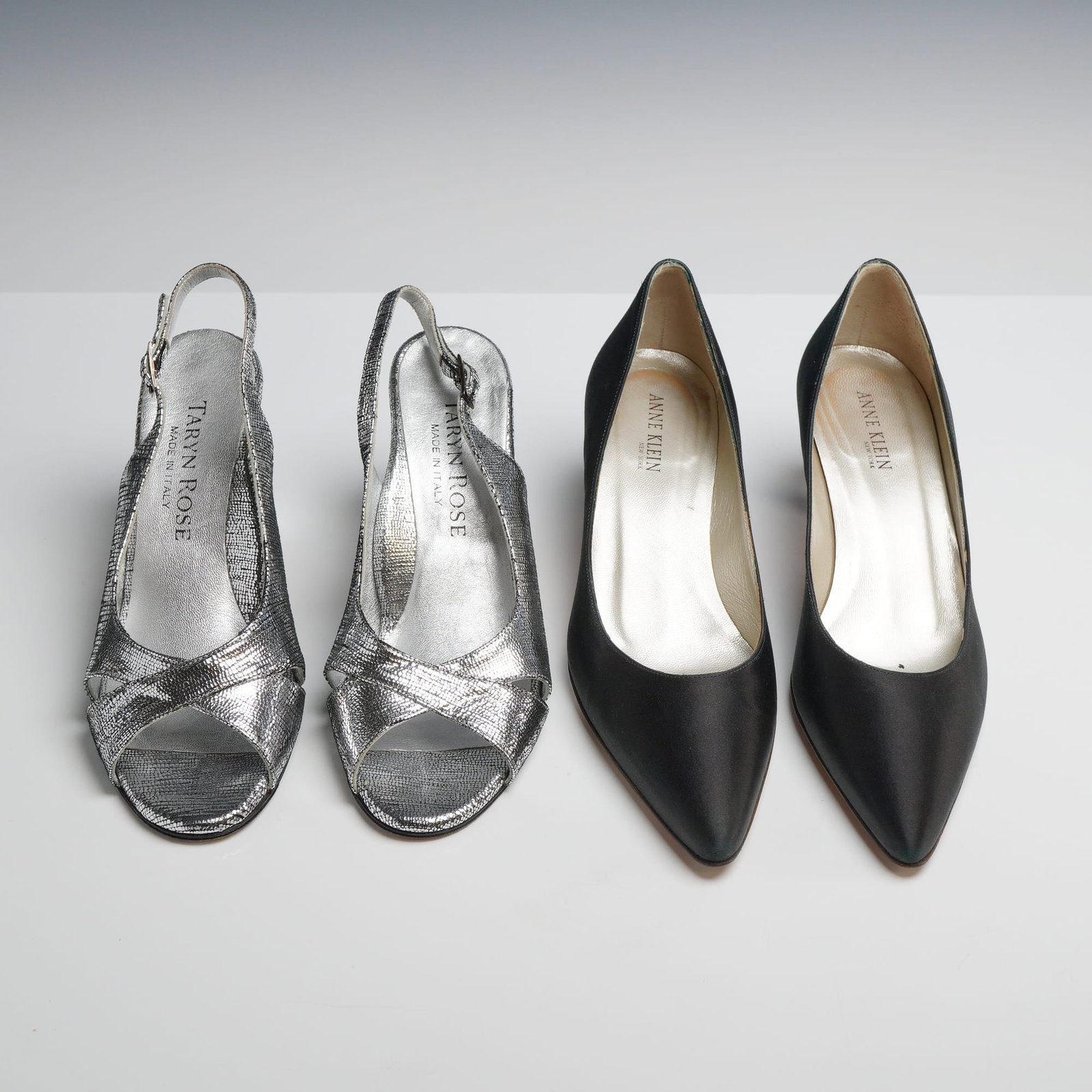 Two Pairs of Designer Heels: Taryn Rose Slingbacks and Anne Klein Pumps, Sizes 35 and 5.5 M, Silver: This lot features two pairs of designer women's heels made in Italy. The first pair consists of Taryn Rose peep-toe slingback pumps featuring a crossover vamp and adjustable buckle strap. These are a