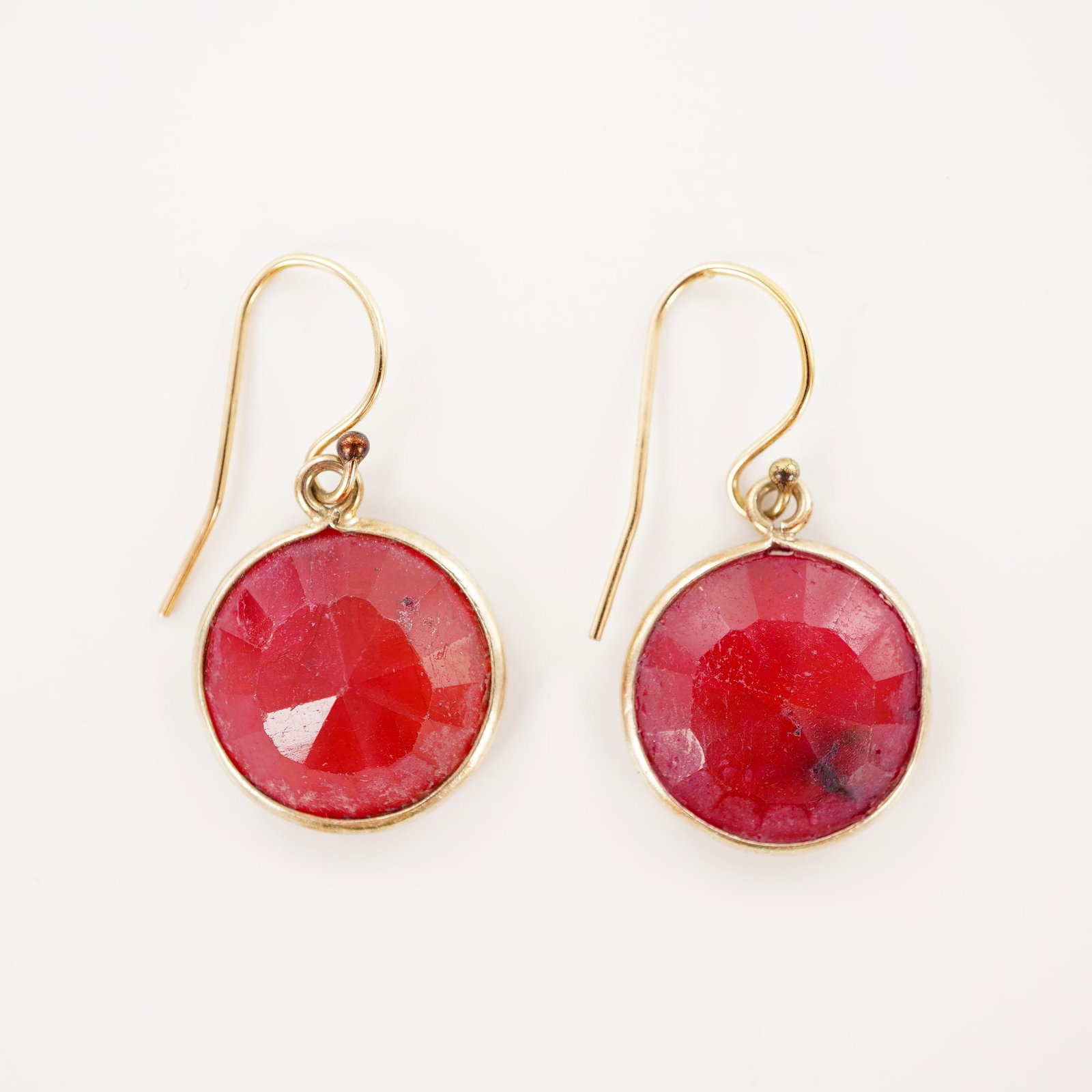 14K Gold Filled Ruby Glass Earrings: Round faceted red glass set in gold filled bezels, each suspended from 1/20 14K gold filled ear wires. Ear wires marked 1/20 14K. DimensionsLength of each earring: 29.6 mm