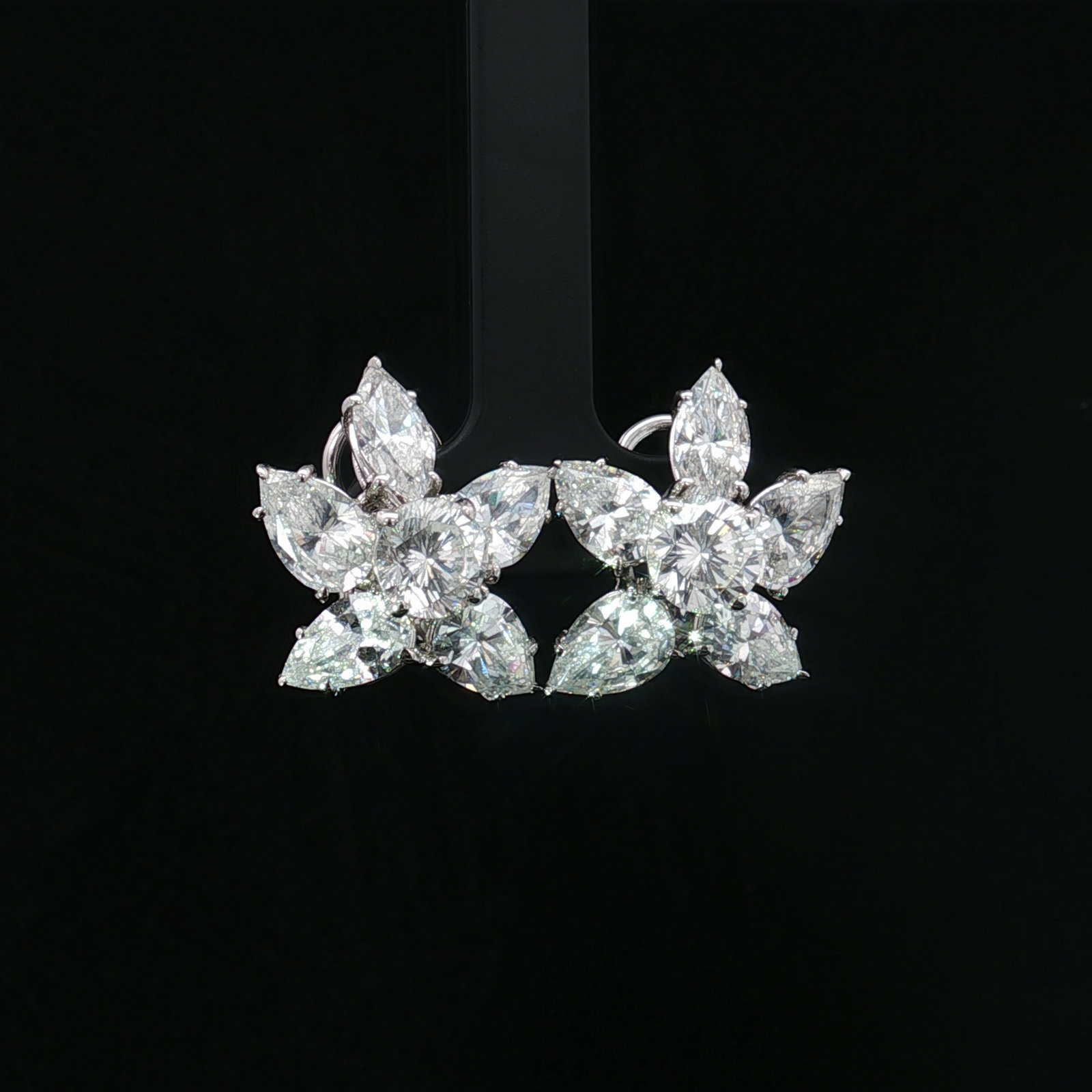 14K White Gold Clear Stone Clip Earrings: A pair of white gold omega-back earrings featuring marquise, pear, and round cut clear stones. The posts are marked 14K. Dimensions1"L x 0.75"W Weight10.6g