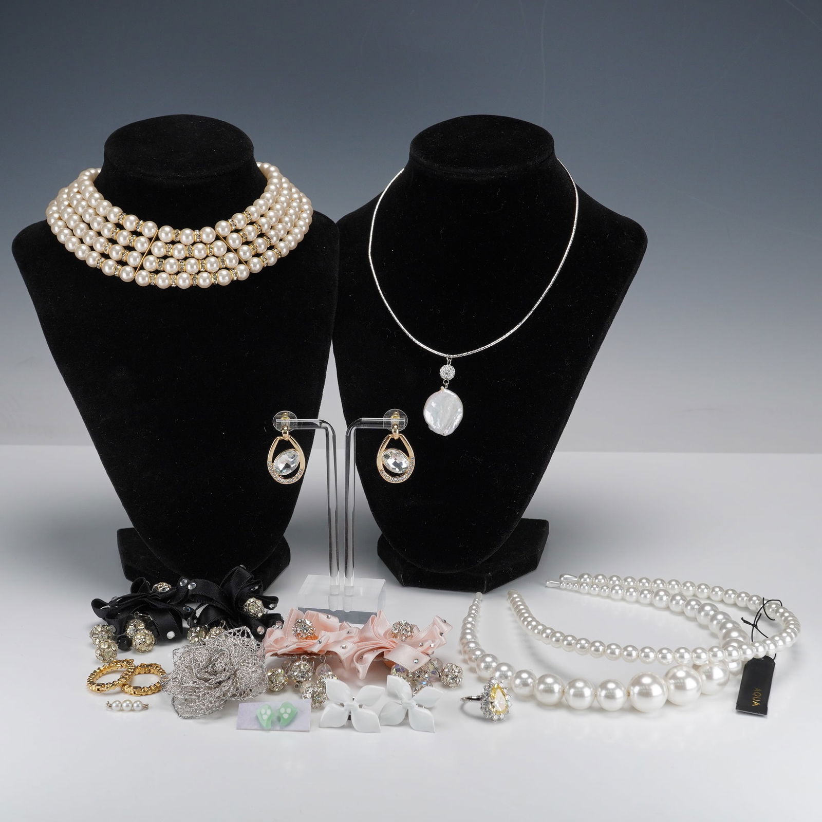 17pc Costume Jewelry, Earrings, Necklaces, Brooches, and Faux-Pearl Hair Accessories: A collection of contemporary costume jewelry and hair accessories, primarily composed of faux pearls, rhinestones, and base metals. The lot includes a four-strand faux pearl and rhinestone choker with