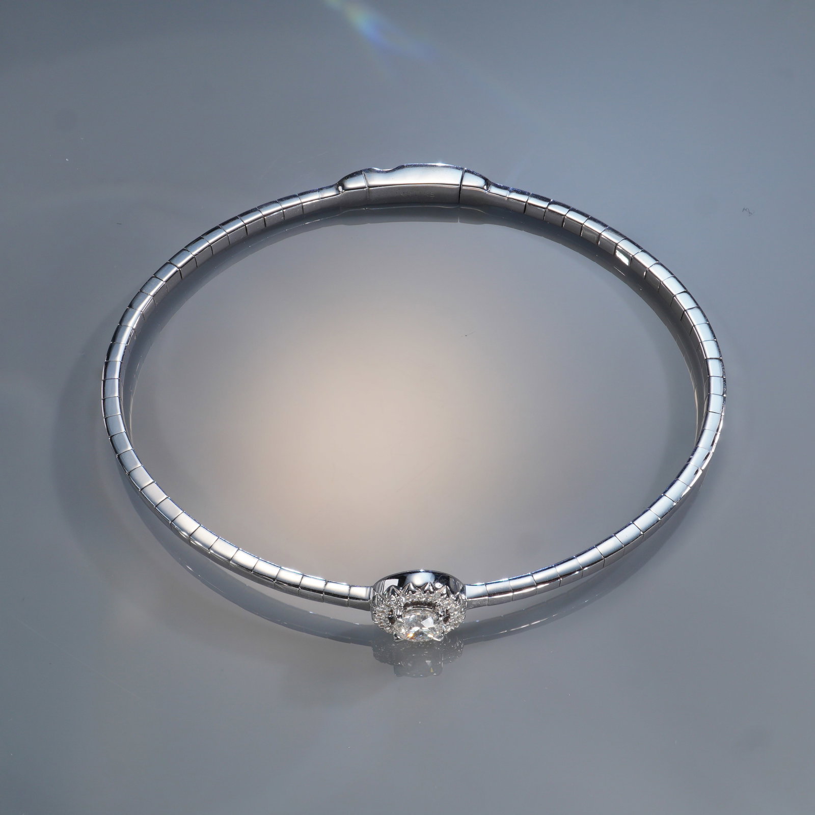 14K White Gold 0.50ctw Diamond Round Bangle: A refined 14K white gold bangle set with a brilliant 0.50 carat total weight of white diamonds. The centerpiece features a sparkling round-cut diamond surrounded by a halo of smaller diamonds, enhanci