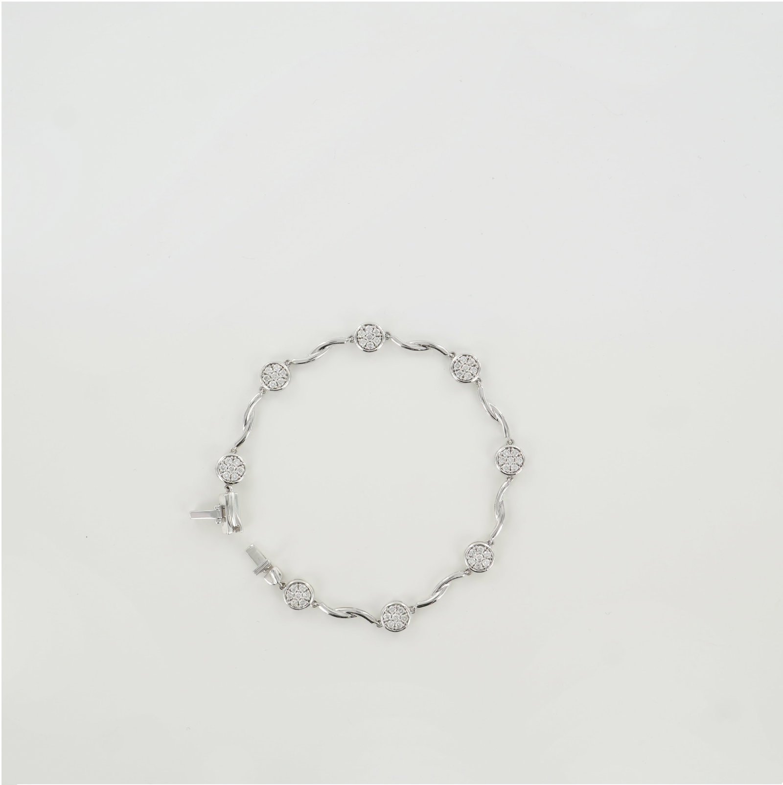 14K White Gold 1.03ctw Diamond Bezel Cluster Bracelet: A stylish 14K white gold bracelet featuring round-cut white diamonds totaling approximately 1.03 carats. Each diamond cluster is securely bezel-set, connected by graceful curved links that add movemen