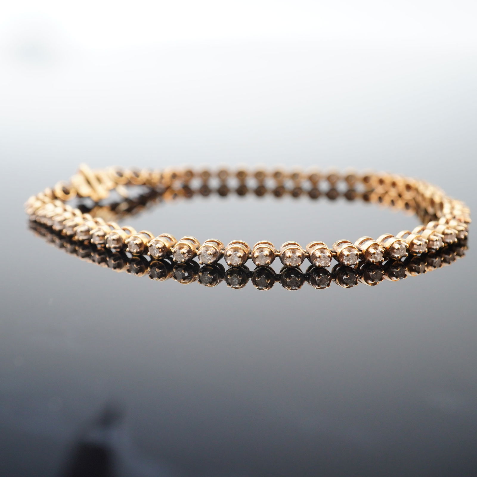 14K Yellow Gold & Diamonds Tennis Bracelet: Crafted in 14K yellow gold, this round cut diamond tennis bracelet that closes with a push-lock clasp. Marked 14KP with hallmarks on the clasp. Dimensions7.25"L Weight7.5g