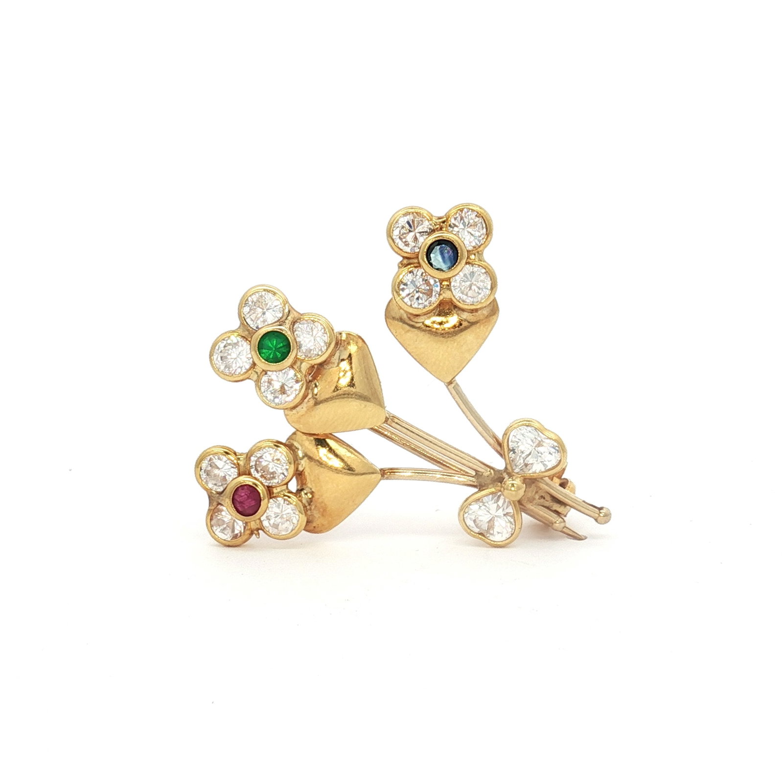18K Gold Ruby, Emerald, Sapphire Flower Bouquet Brooch: An 18K yellow gold brooch designed as a bouquet of flowers with heart accents. Each flower features clear stones as petals, each set with emerald, ruby, and sapphire centers. The reverse is marked 750