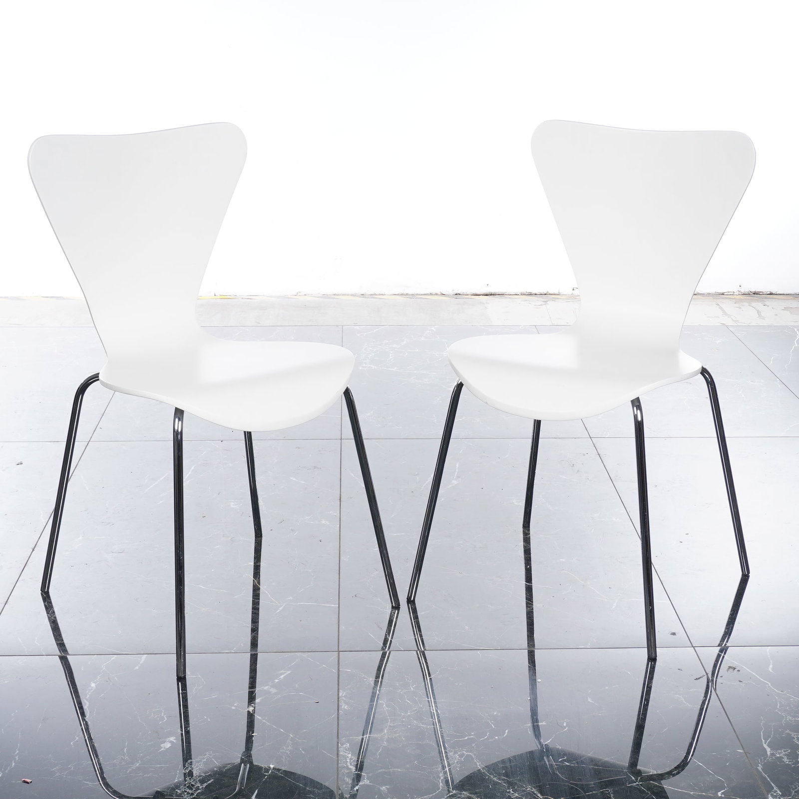Pair of Room & Board White Molded Plywood Side Chairs: This matched pair of contemporary side chairs by Room & Board features a minimalist Mid-Century Modern silhouette inspired by classic Danish design. Each chair is constructed from a single-piece molde