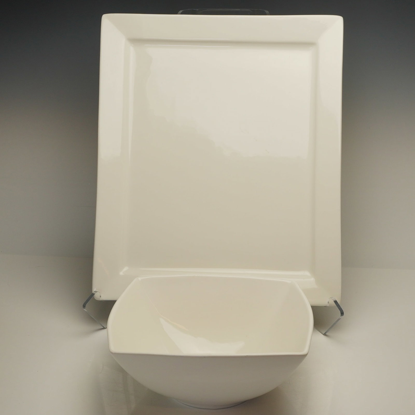 2pc 10 Strawberry Street Platter and Serving Bowl: The pieces are constructed of ceramic with a glossy off-white glaze. The rectangular 17.5" tray bears the manufacturer mark for 10 Strawberry Street on the underside. The square-rimmed bowl is unmarke