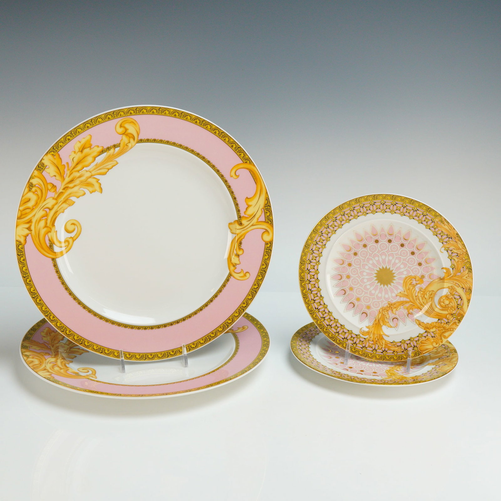 4pc Rosenthal Versace Porcelain Plate Set, Les Reves Byzantins: The set consists of two 10.5" dinner plates and two 7.25" side plates. The dinner plates feature a broad pastel pink rim decorated with golden acanthus leaf scrollwork. The side plates are designed wi