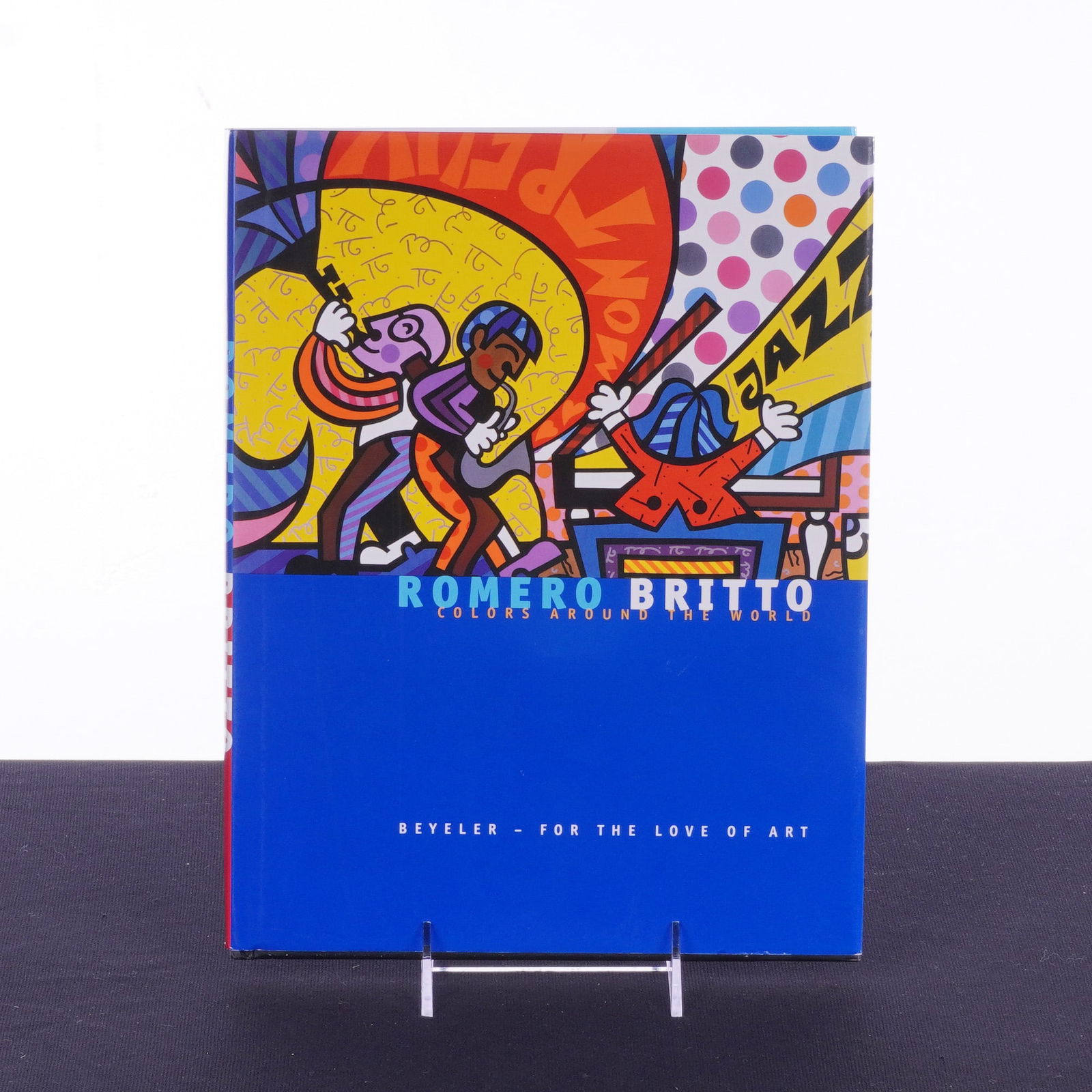 First Edition Hardcover Book, Romero Britto, Colors Around the World: First edition hardcover book with original pictorial dust jacket authored by Brazilian artist Romero Britto. Titled Romero Britto: Colors Around the World, it was published in Birkenhalde by Beyeler -
