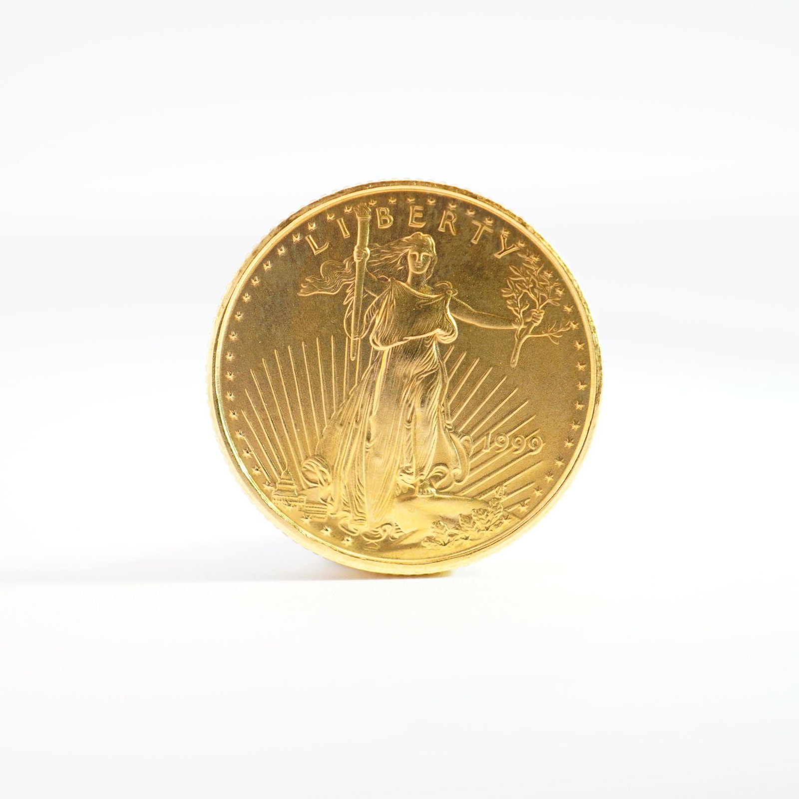 1999 1/10 Fine Gold $5 American Gold Eagle Coin: Minted by the Philadelphia Mint. The obverse side depicts an effigy of Liberty with the date to the right. The obverse side depicts an eagle in flight above a nest of birds with the country name at th