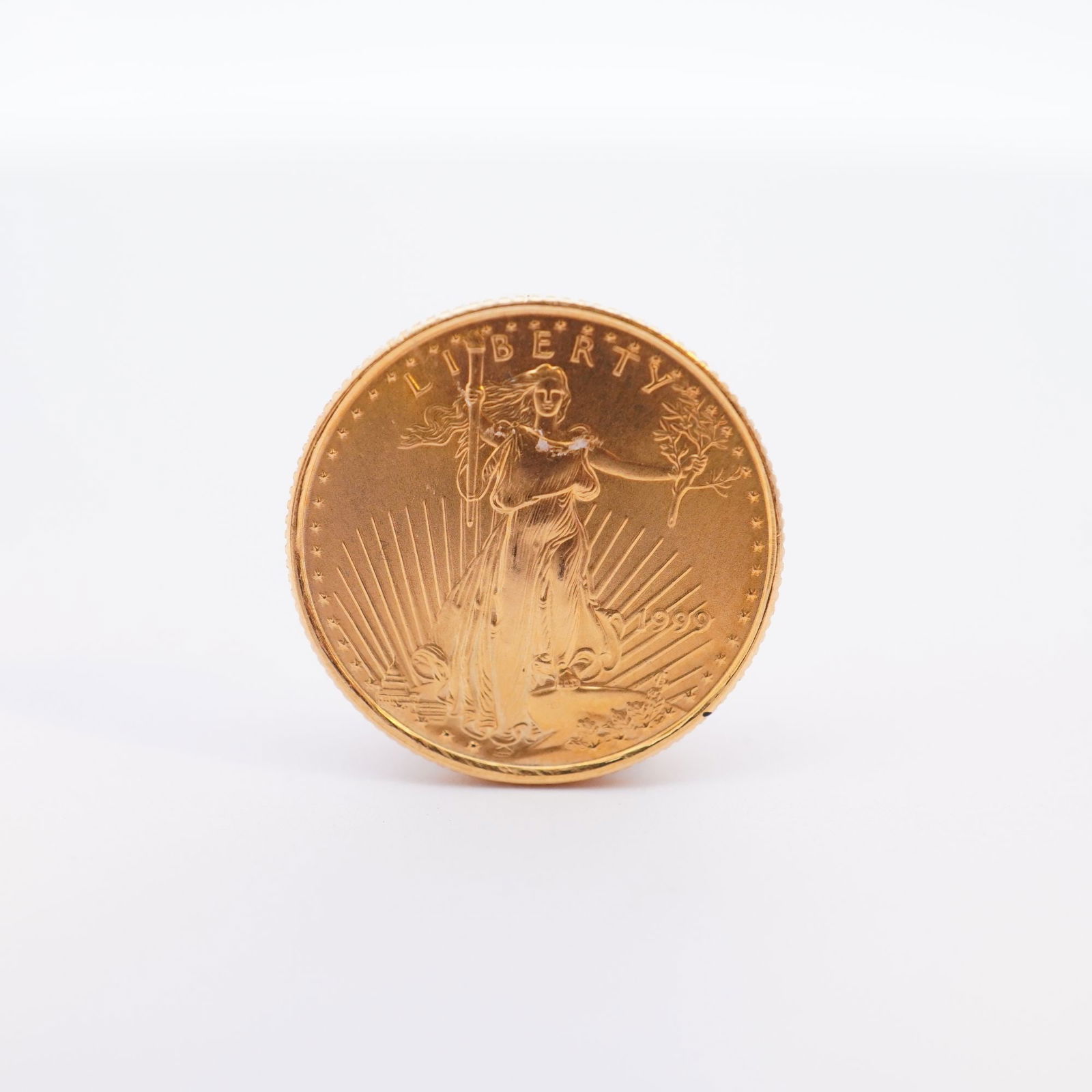 1999 1/10 Fine Gold $5 American Gold Eagle Coin: Minted by the Philadelphia Mint. The obverse side depicts an effigy of Liberty with the date to the right. The reverse side depicts an eagle in flight above a nest of birds with the country name at th