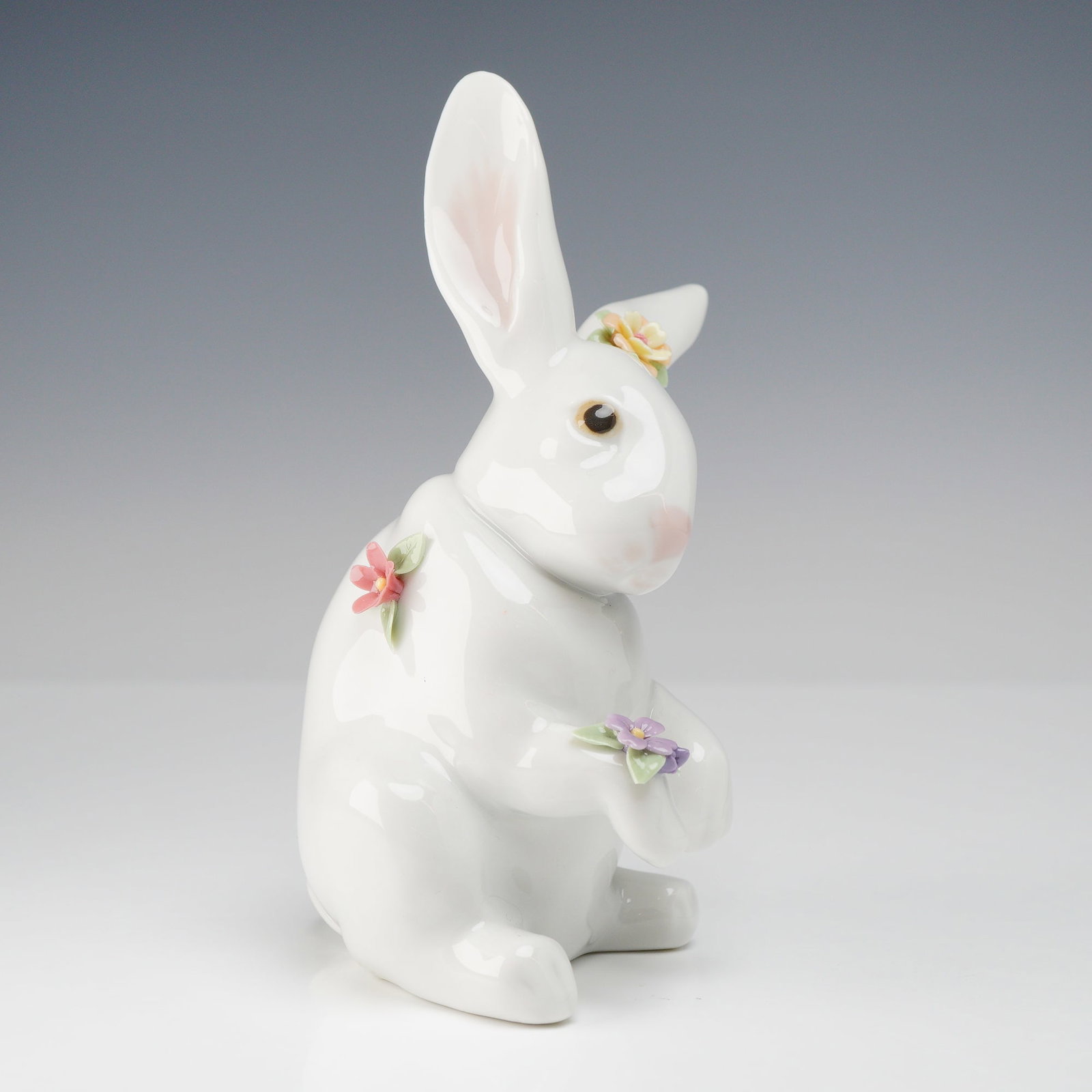 Lladro Sitting Bunny with Flowers Figurine #6100: A vintage Lladro porcelain figurine titled Sitting Bunny with Flowers, model number 6100. This piece features a naturalistically modeled white rabbit in a seated pose, adorned with delicate, hand-appl